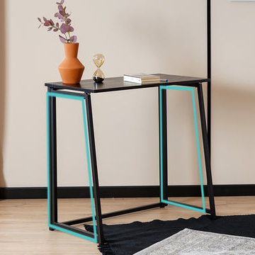 Modern side table with black and turquoise legs in a room setting.