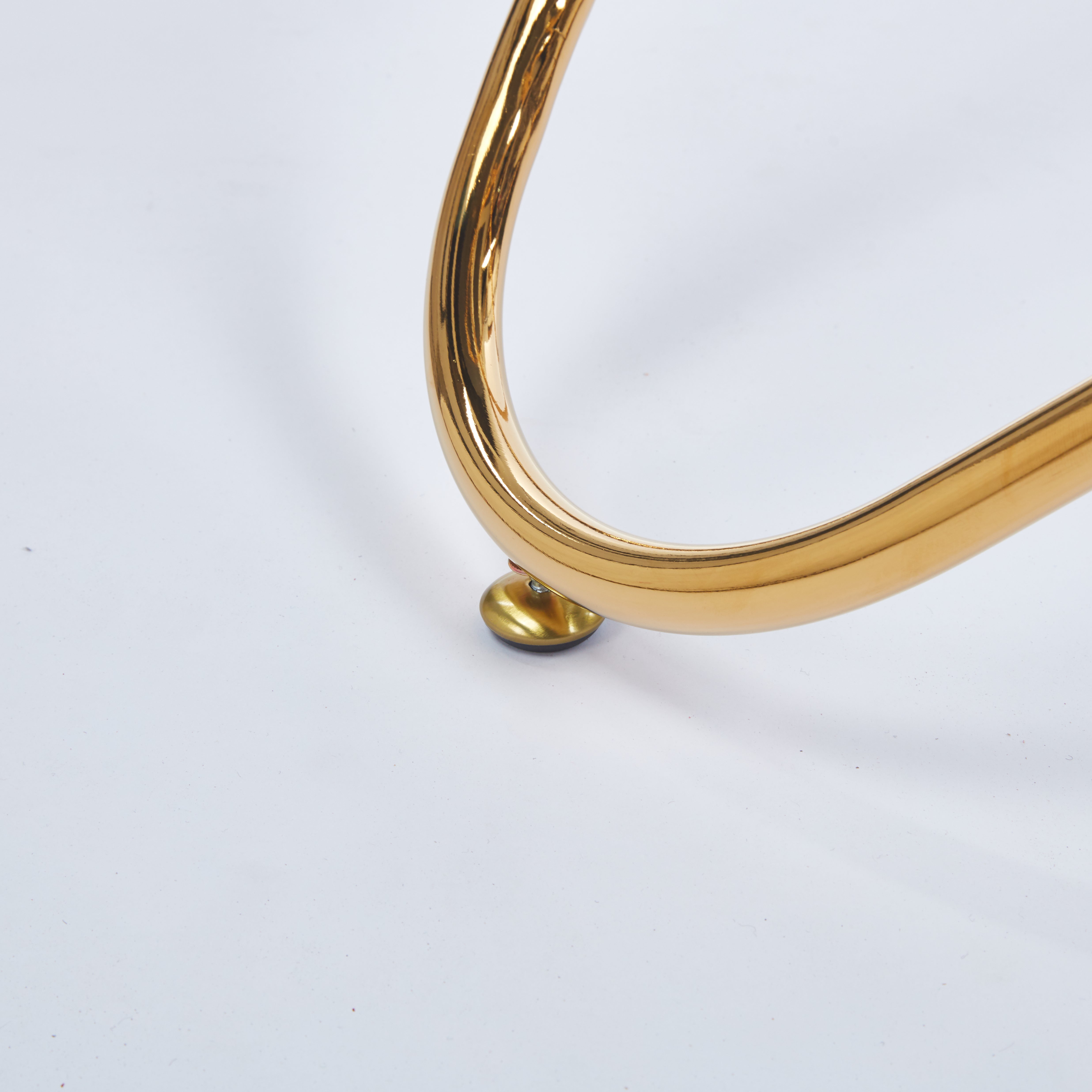 Adriatic gold dining table showing gold metal leg tip detail