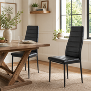 Ann black faux leather dining chair set of 2 styled at a wooden dining table in a bright dining room