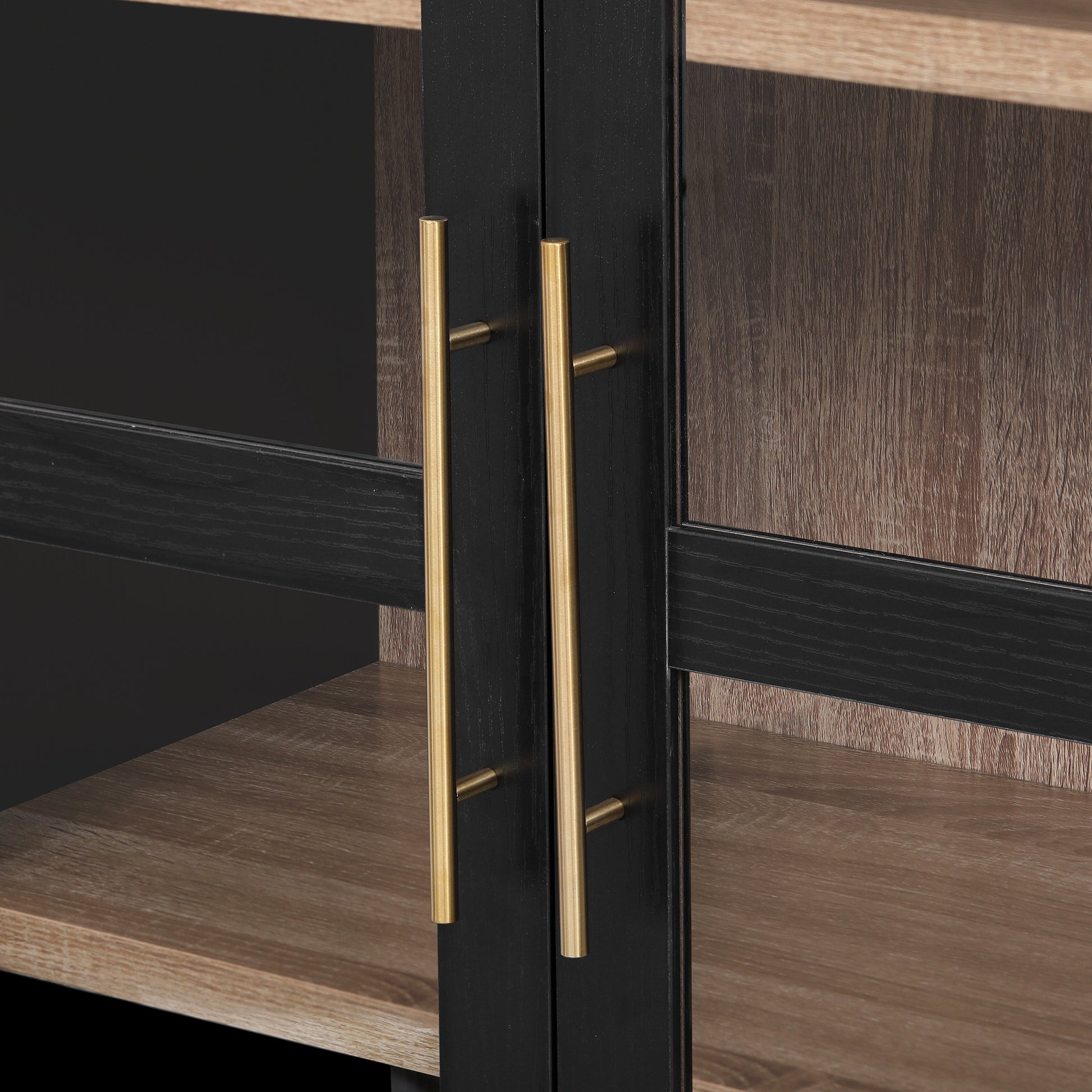 Close-up detail of the gold metal handles on the black Artisan glass door pantry cabinet showcasing modern farmhouse hardware and wood grain shelving interior