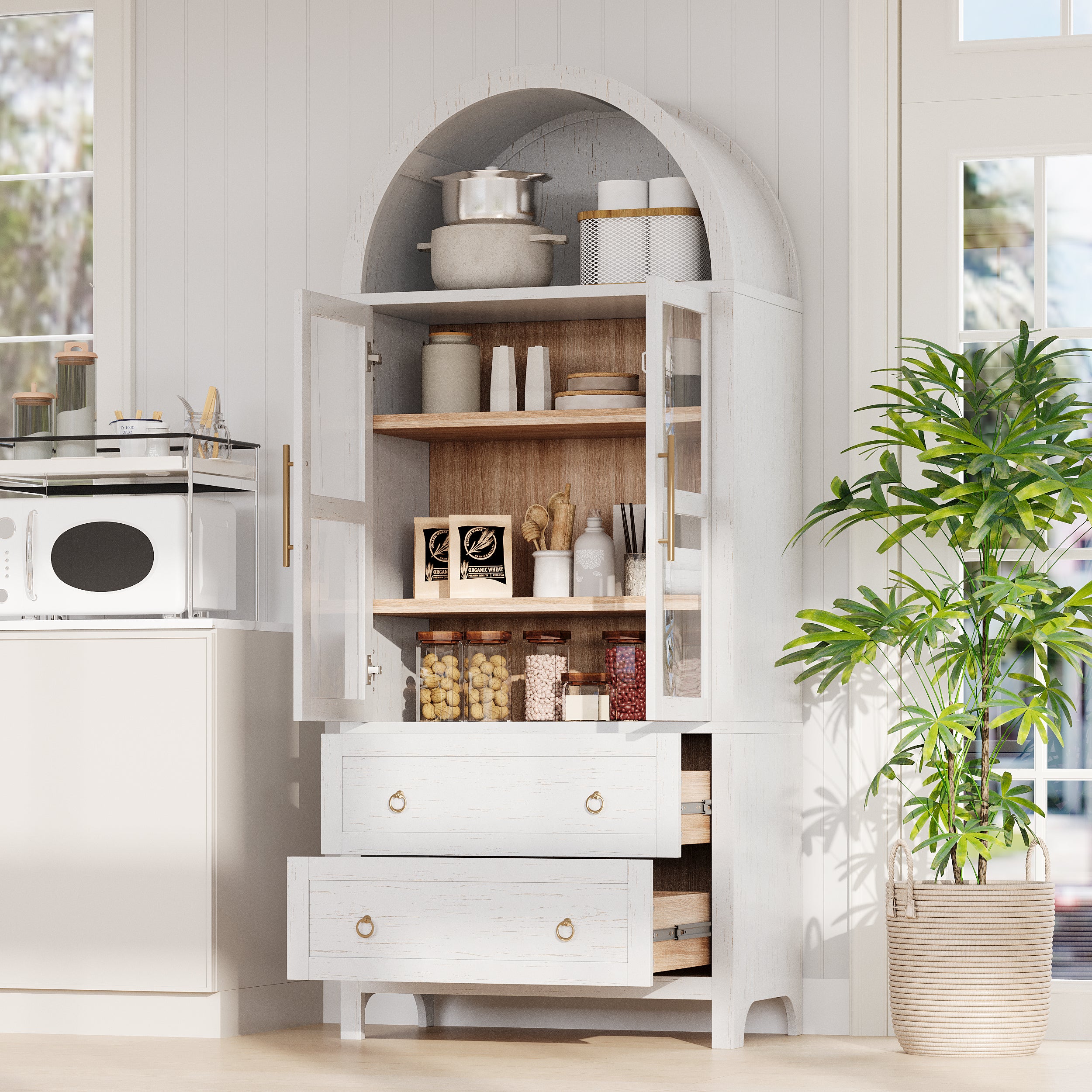 White Artisan 71 - inch arched pantry cabinet with open glass doors and pull - out drawers displaying organized kitchen storage in a bright farmhouse kitchen scene
