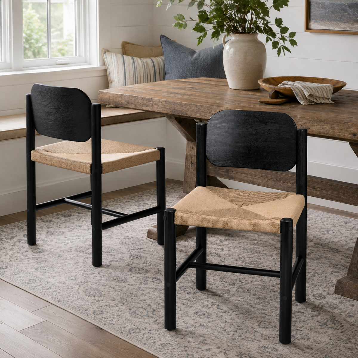Arve black dining chair showing two chairs beside a wood dining table in a bright dining room