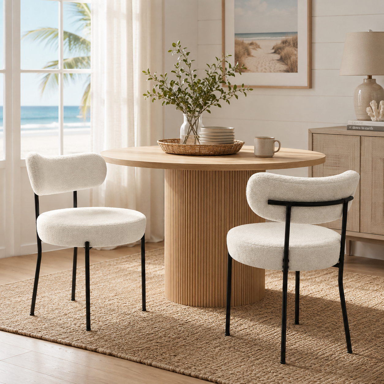 Bled white round upholstered dining chairs with curved backs and black metal legs around a round wood dining table