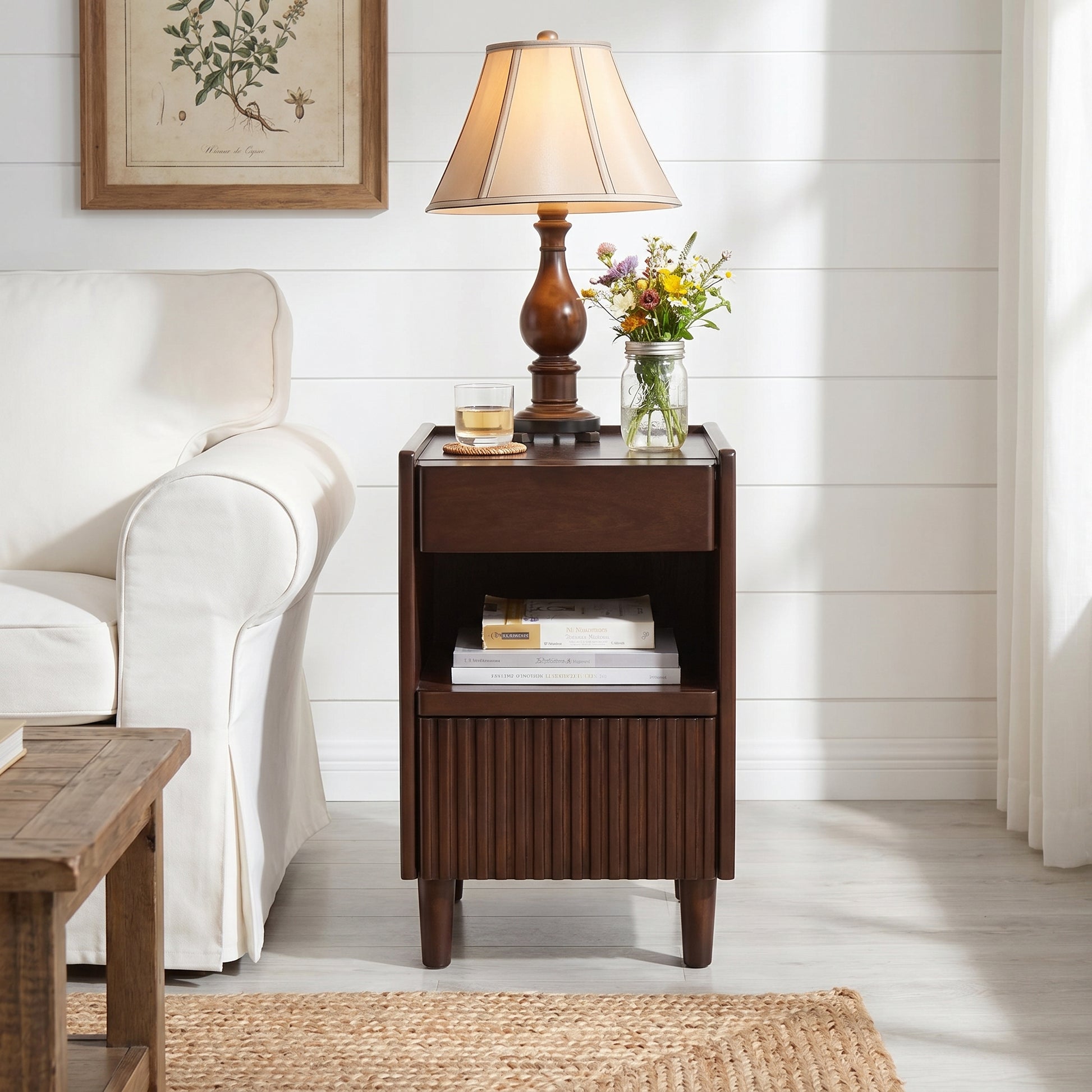 Brennor walnut nightstand showing angled front view beside a sofa