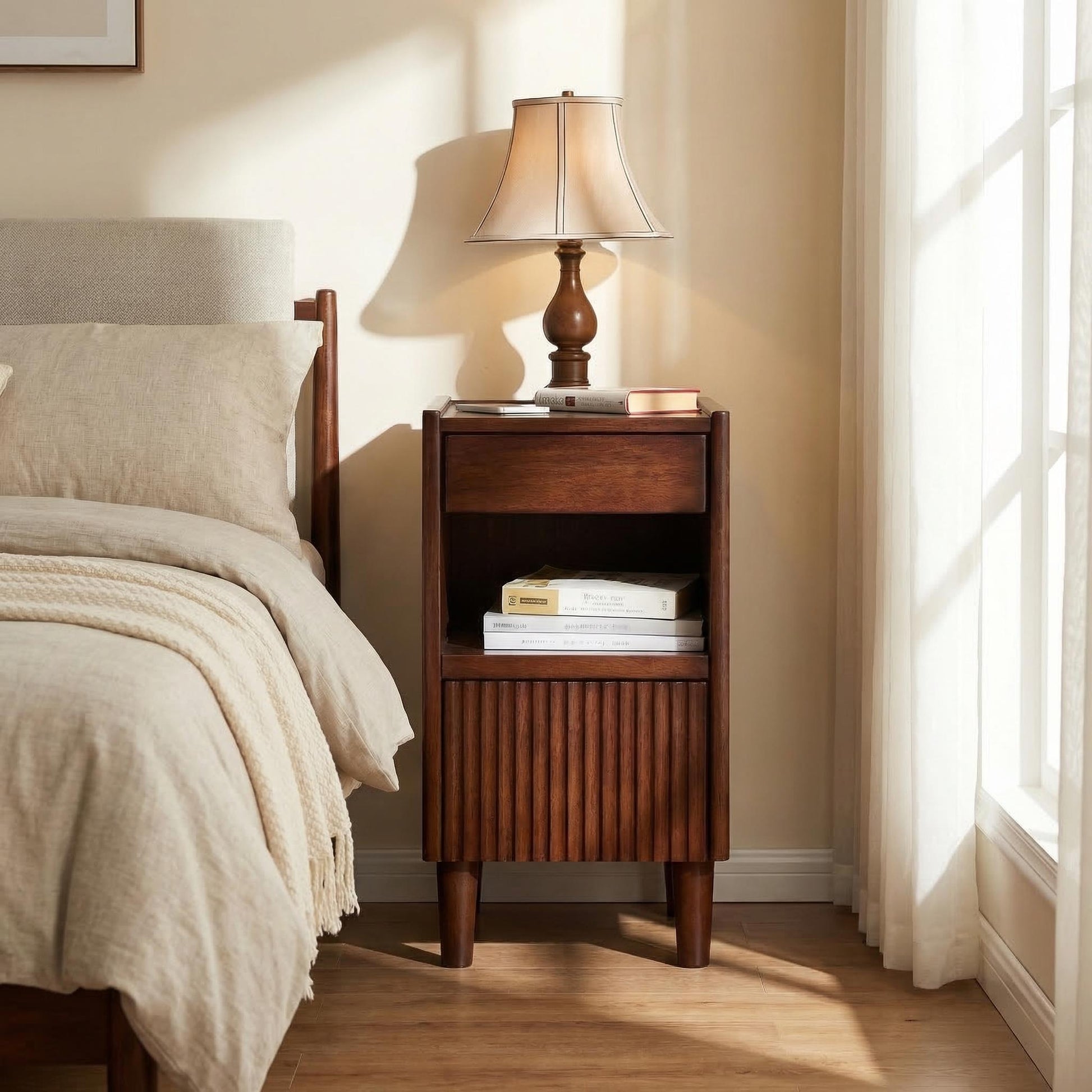 Brennor walnut nightstand showing side placement beside a bed