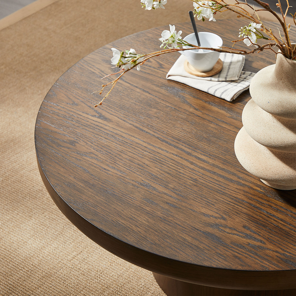 Brutoni brown round coffee table close-up showing the thick oak-toned tabletop and wood grain