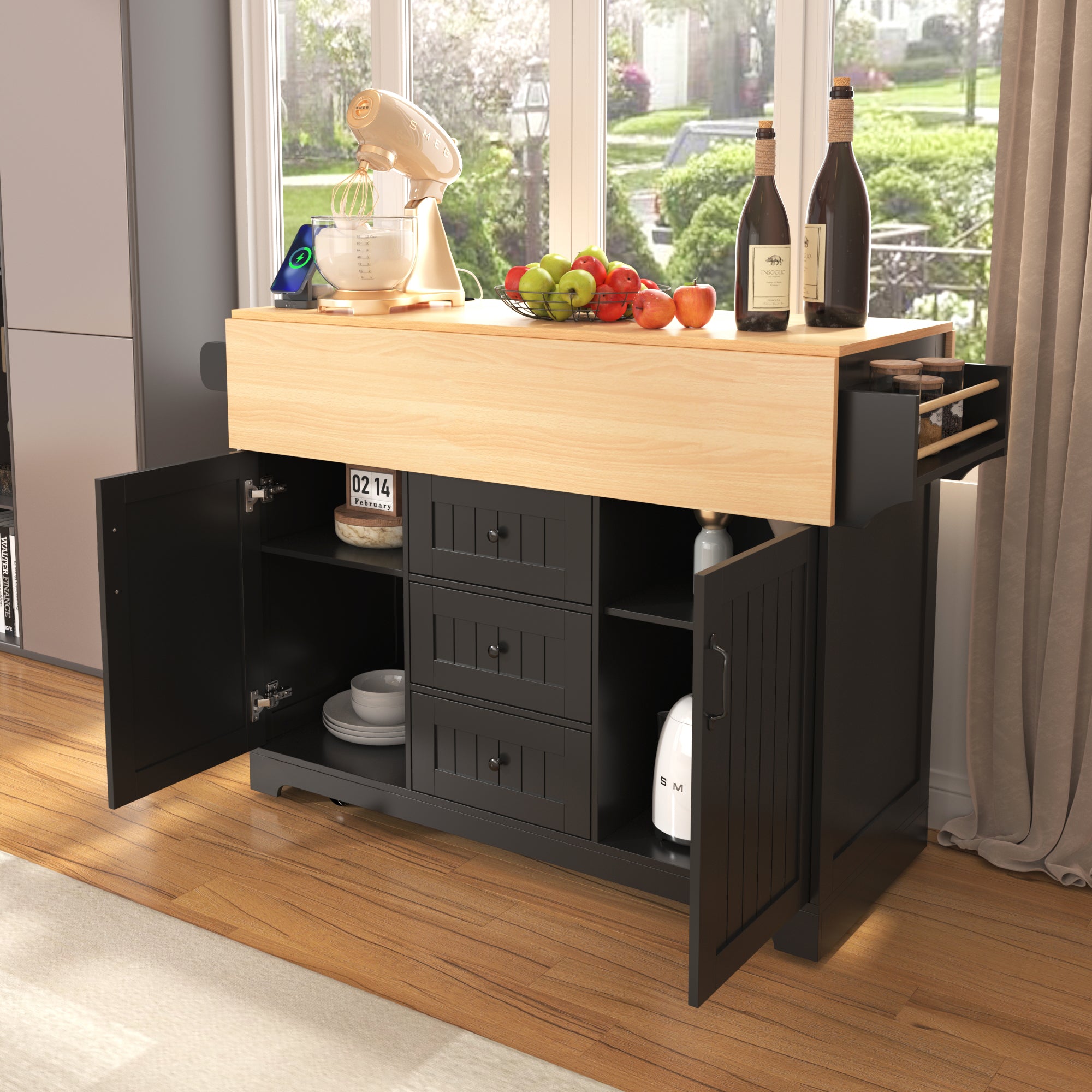 Lifestyle view of the black BRYNNA rolling kitchen island with folded drop leaf tabletop, open cabinet storage, center drawers, spice rack, and compact multifunctional kitchen design