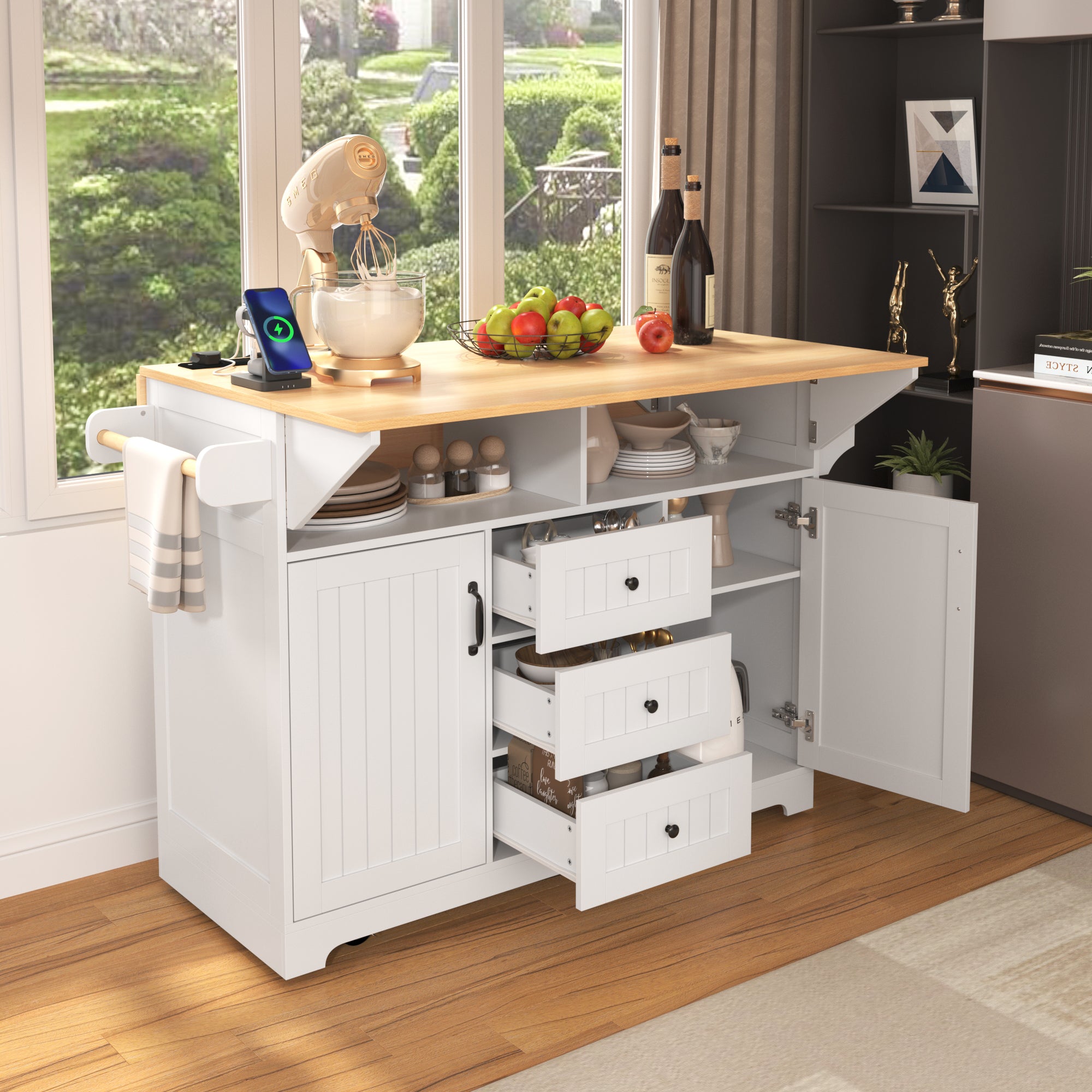 Lifestyle image of the white BRYNNA rolling kitchen island with open drawers, cabinet storage, towel rack, charging station, and multifunctional farmhouse kitchen organization design