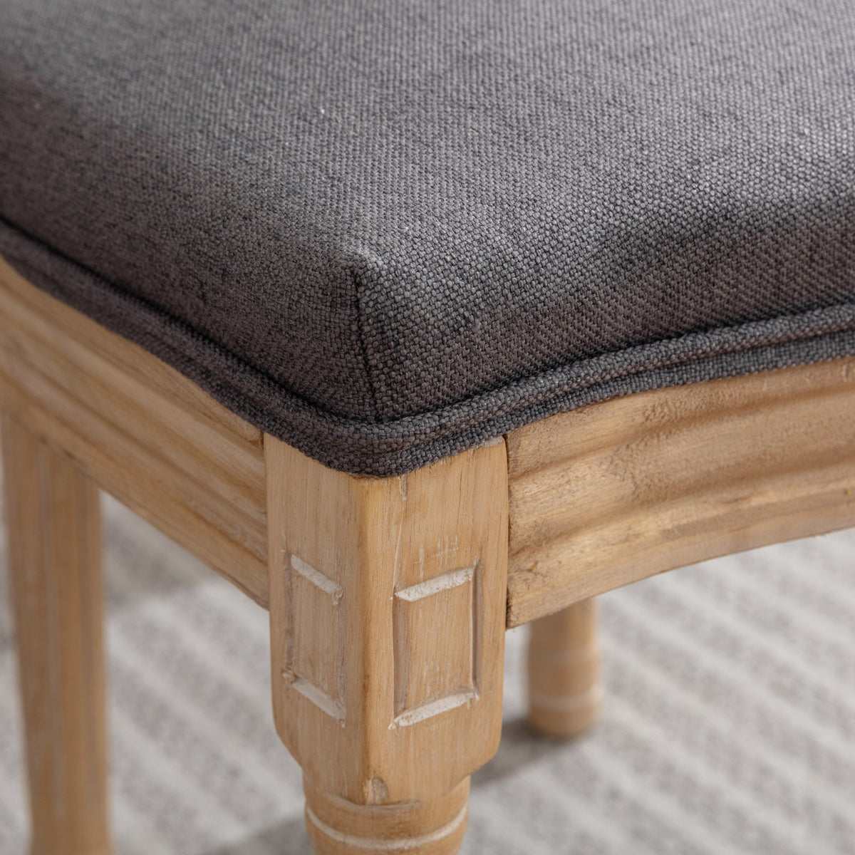 Celeste gray dining chair close-up of the upholstered seat and natural wood frame