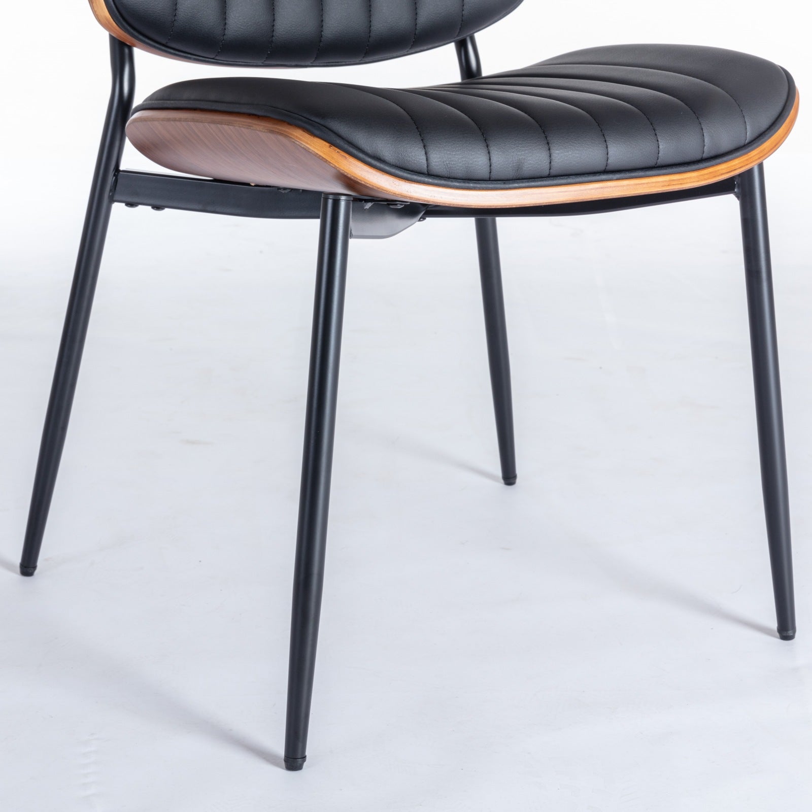 Colorado black dining chair close-up of the upholstered seat underside and slim black metal leg