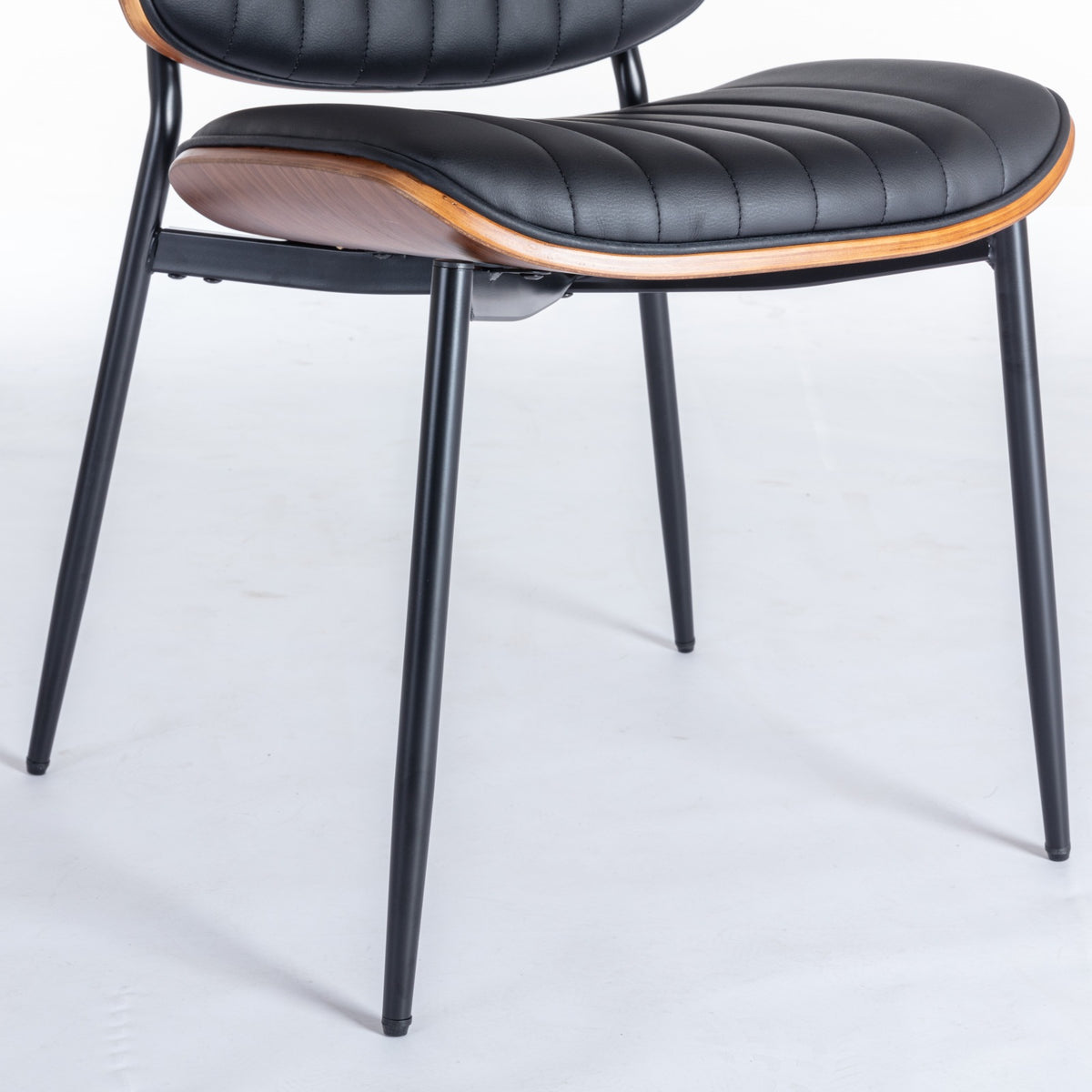 Colorado black dining chair close-up of the upholstered seat underside and slim black metal leg