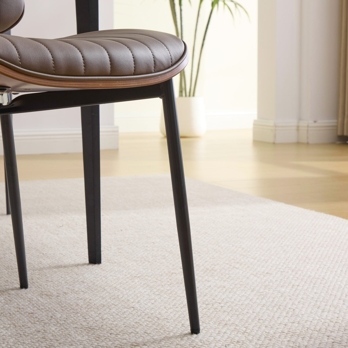 Colorado brown dining chair close-up of the upholstered seat underside and slim black metal leg