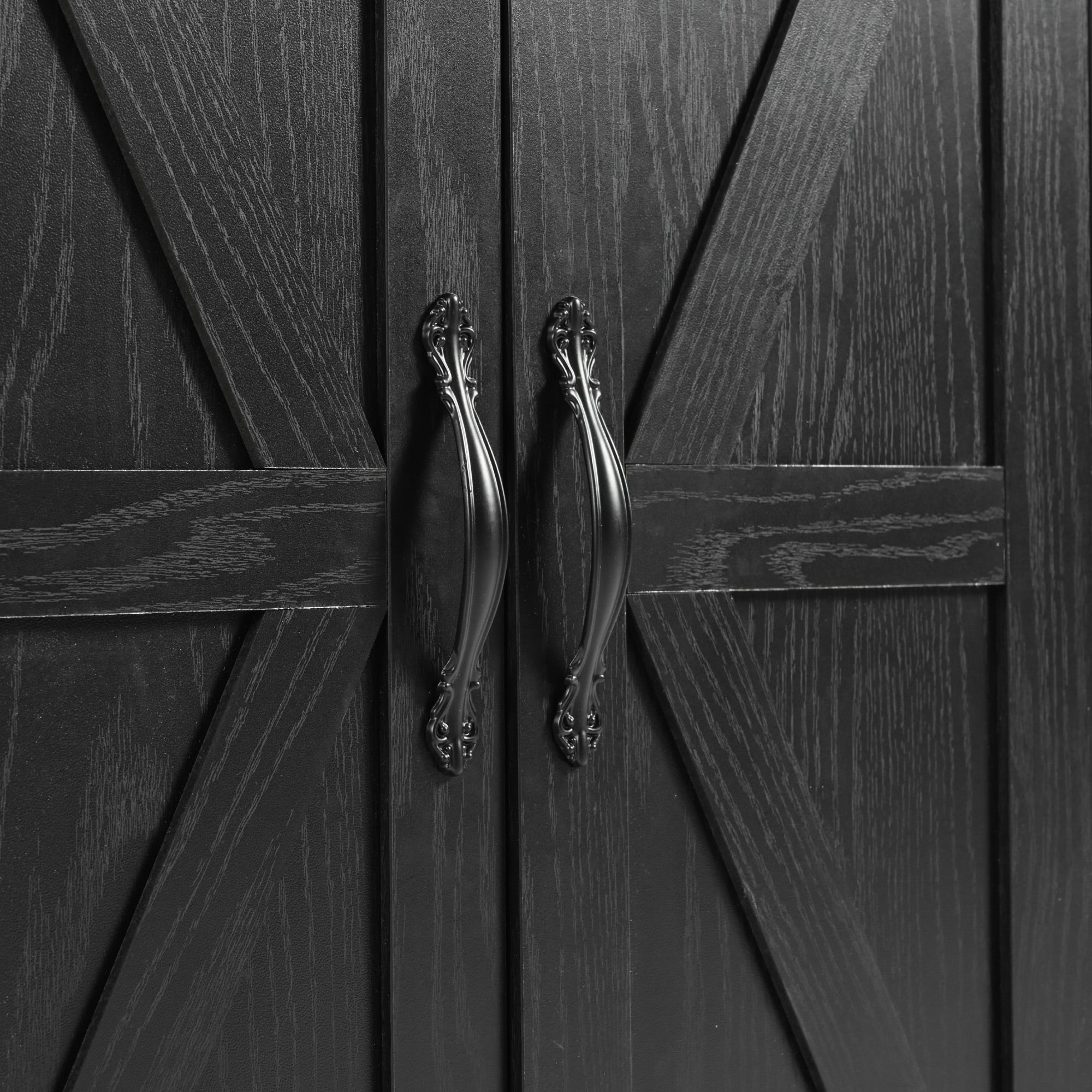 Close-up detail of black barn door handles and wood grain cabinet doors on Dijon farmhouse rolling kitchen island isolated on white background