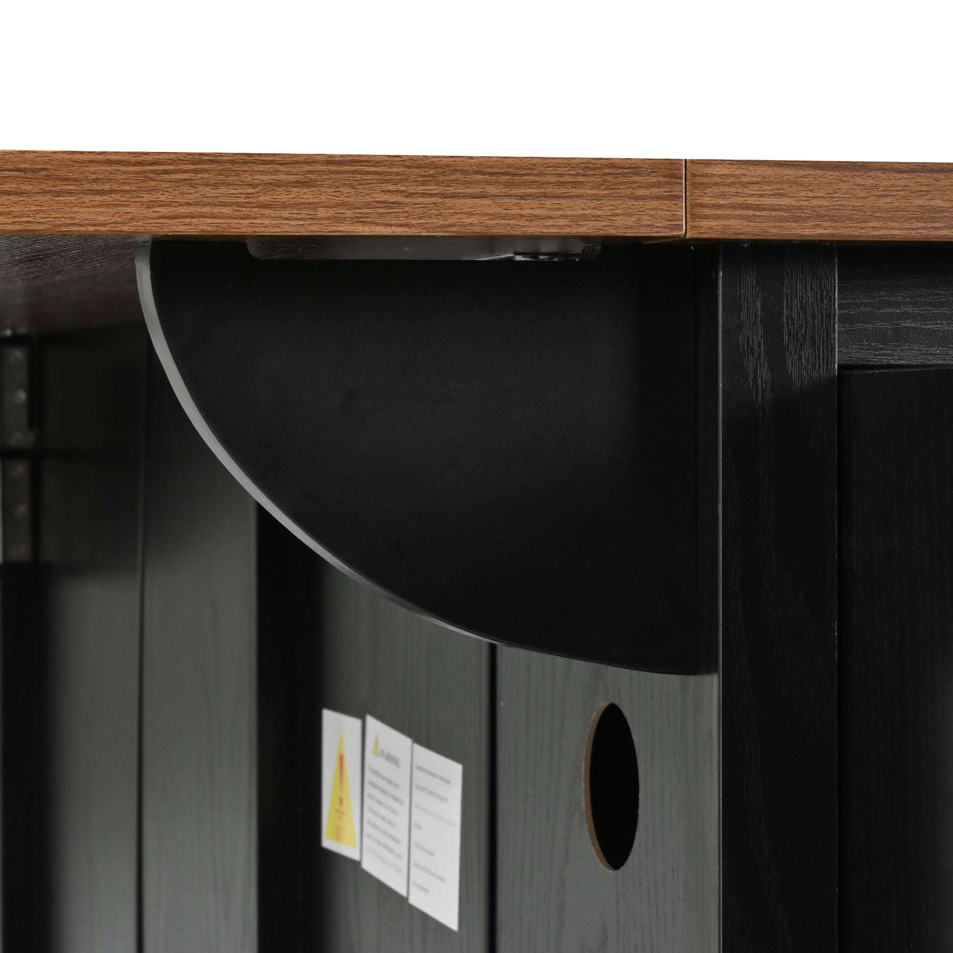 Close-up detail of drop leaf support bracket and cable management hole on black Dijon farmhouse rolling kitchen island isolated on white background
