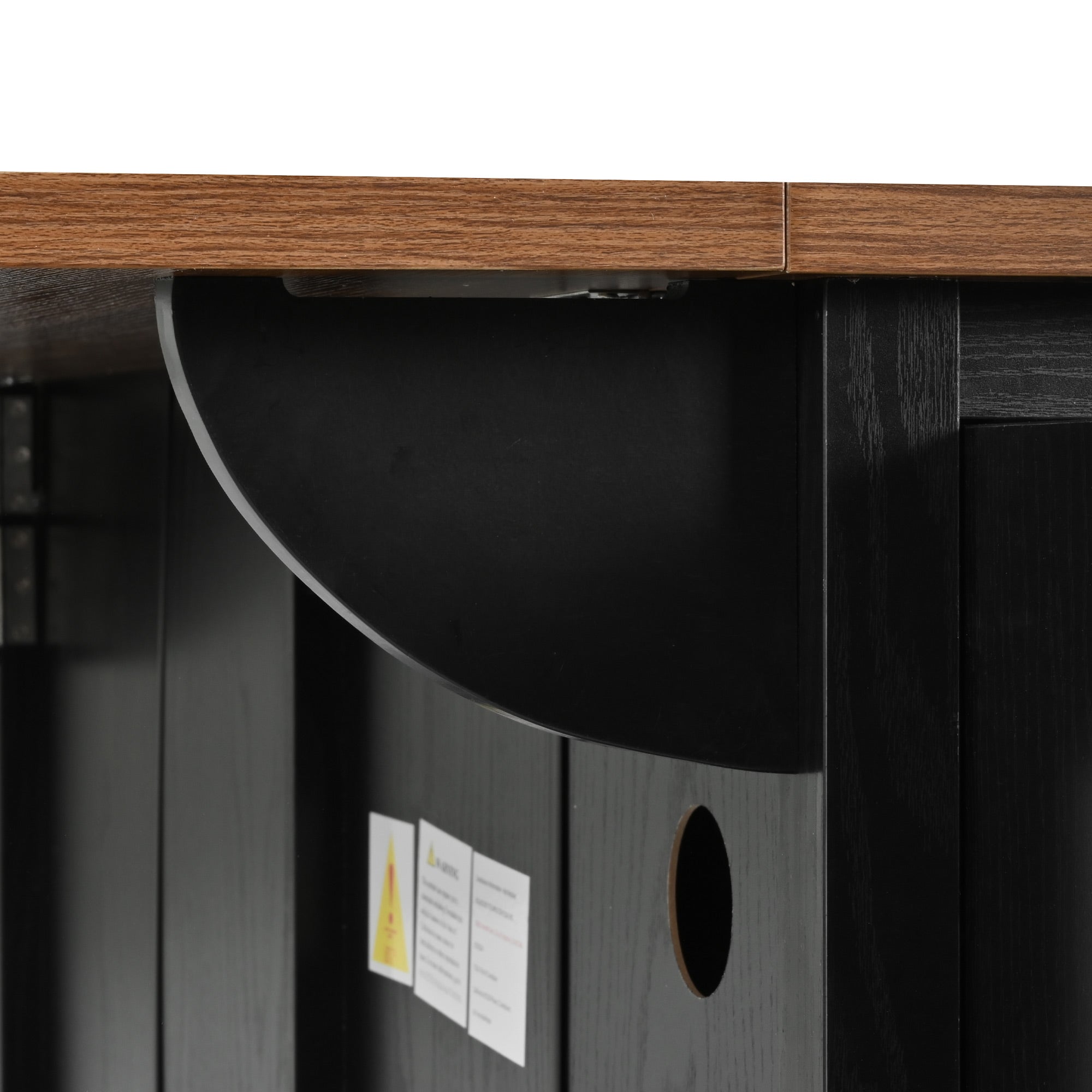 Close-up detail of drop leaf support bracket and cable management hole on black Dijon farmhouse rolling kitchen island isolated on white background