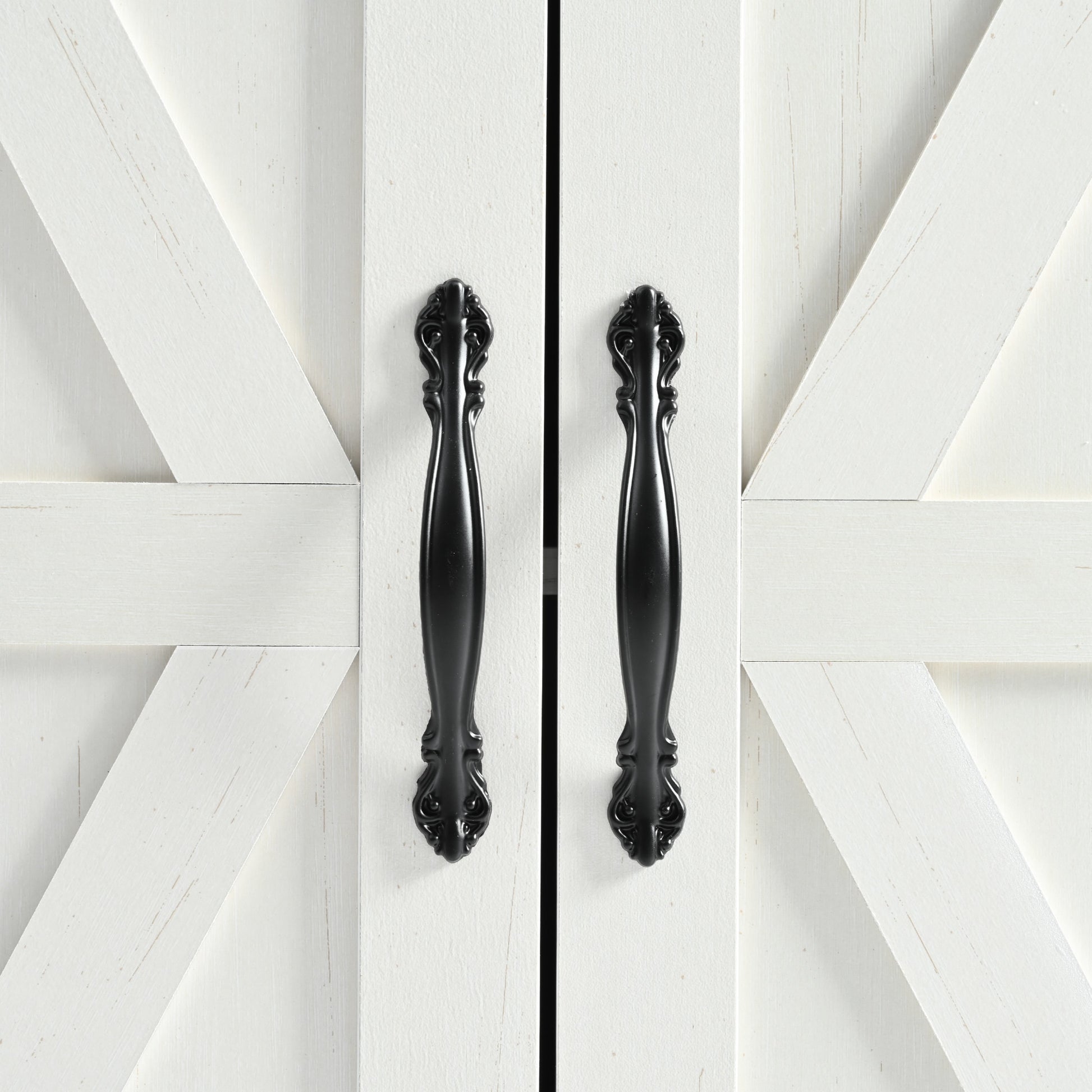Close-up detail of black metal cabinet handles and barn door panel design on white Dijon farmhouse rolling kitchen island isolated on white background