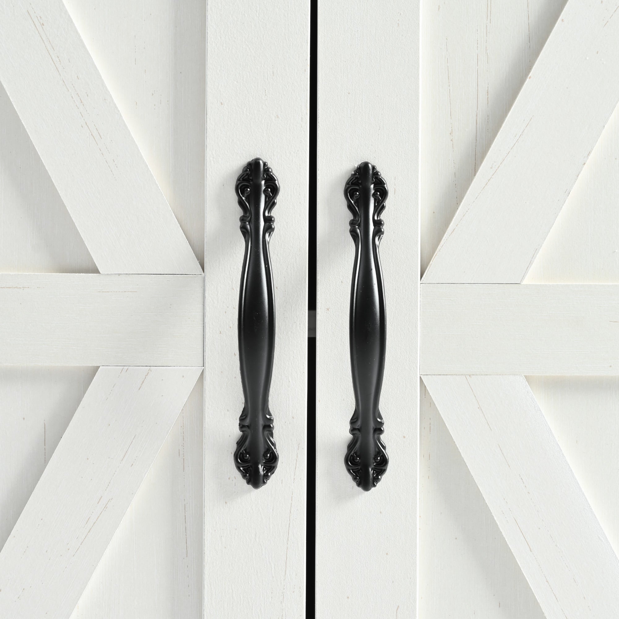 Close-up detail of black metal cabinet handles and barn door panel design on white Dijon farmhouse rolling kitchen island isolated on white background
