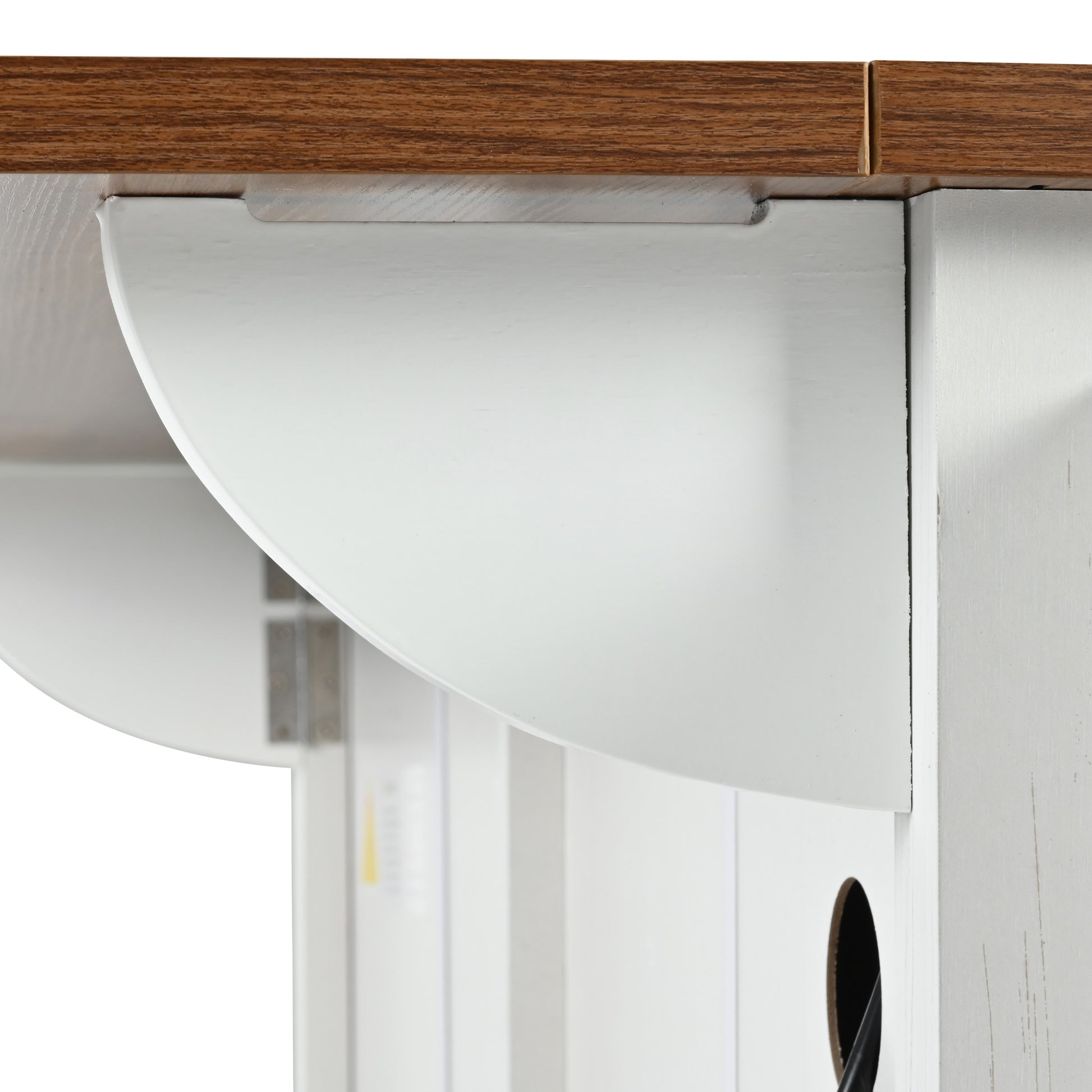 Close-up view of drop leaf support bracket and cable management hole on white Dijon farmhouse rolling kitchen island with wood countertop isolated on white background