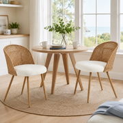 Drava beige dining chairs showing a pair around a round wood table in a bright room with large windows