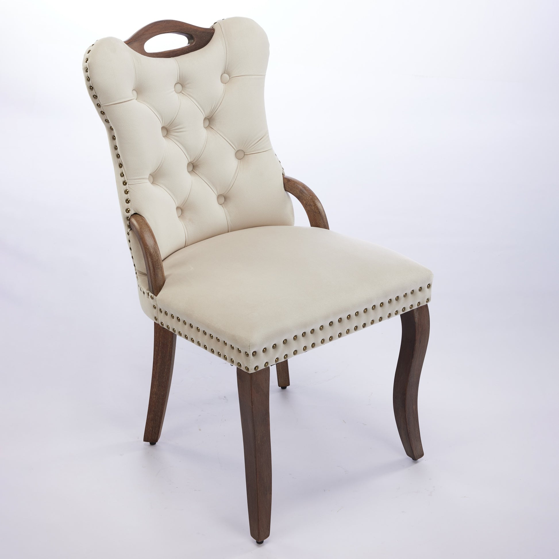 Elbe beige dining chair showing an angled front view with wood armrests and nailhead trim