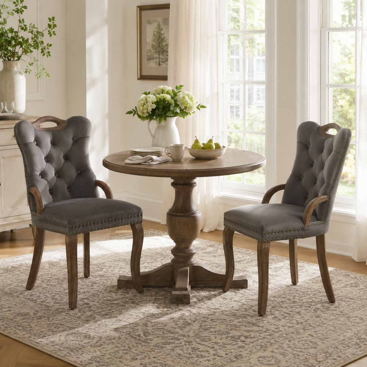Elbe gray dining chairs showing a pair around a round pedestal table beside tall windows