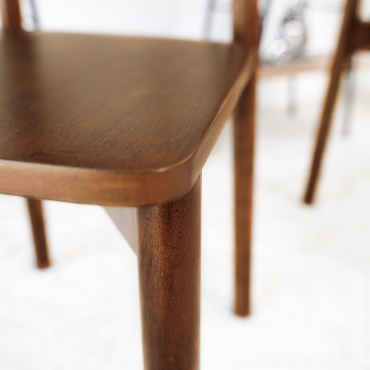 Euphrates brown dining chair close-up of the curved backrest and solid wood frame joint