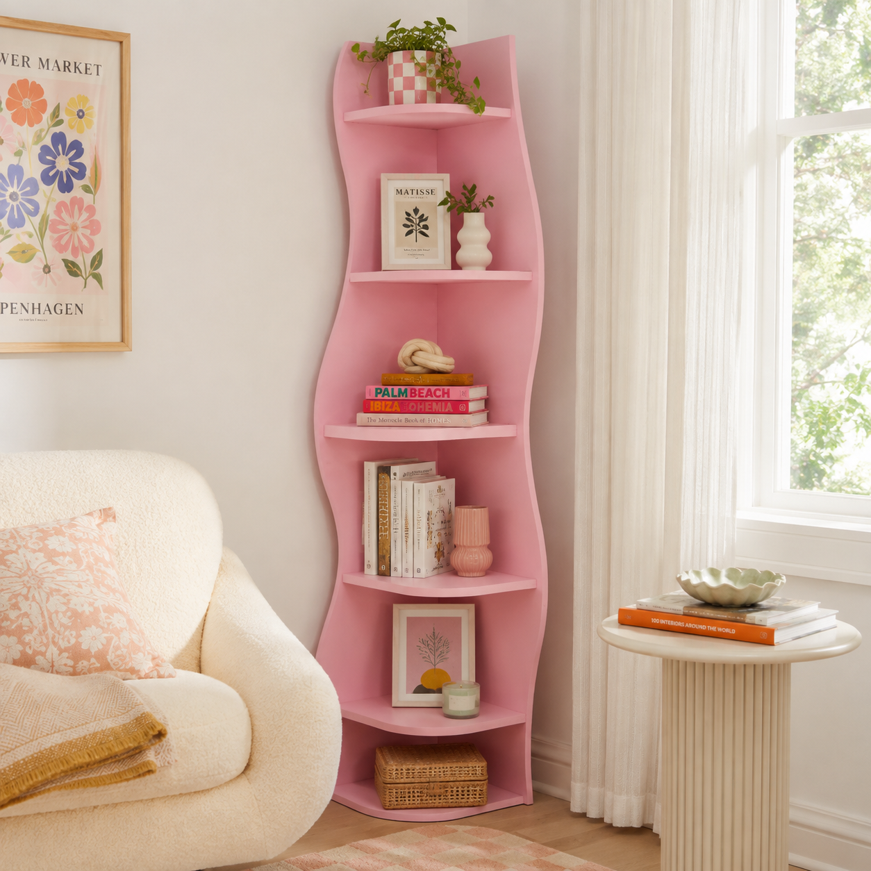 Eureka pink corner bookcase showing books and decor beside an armchair in a playful room