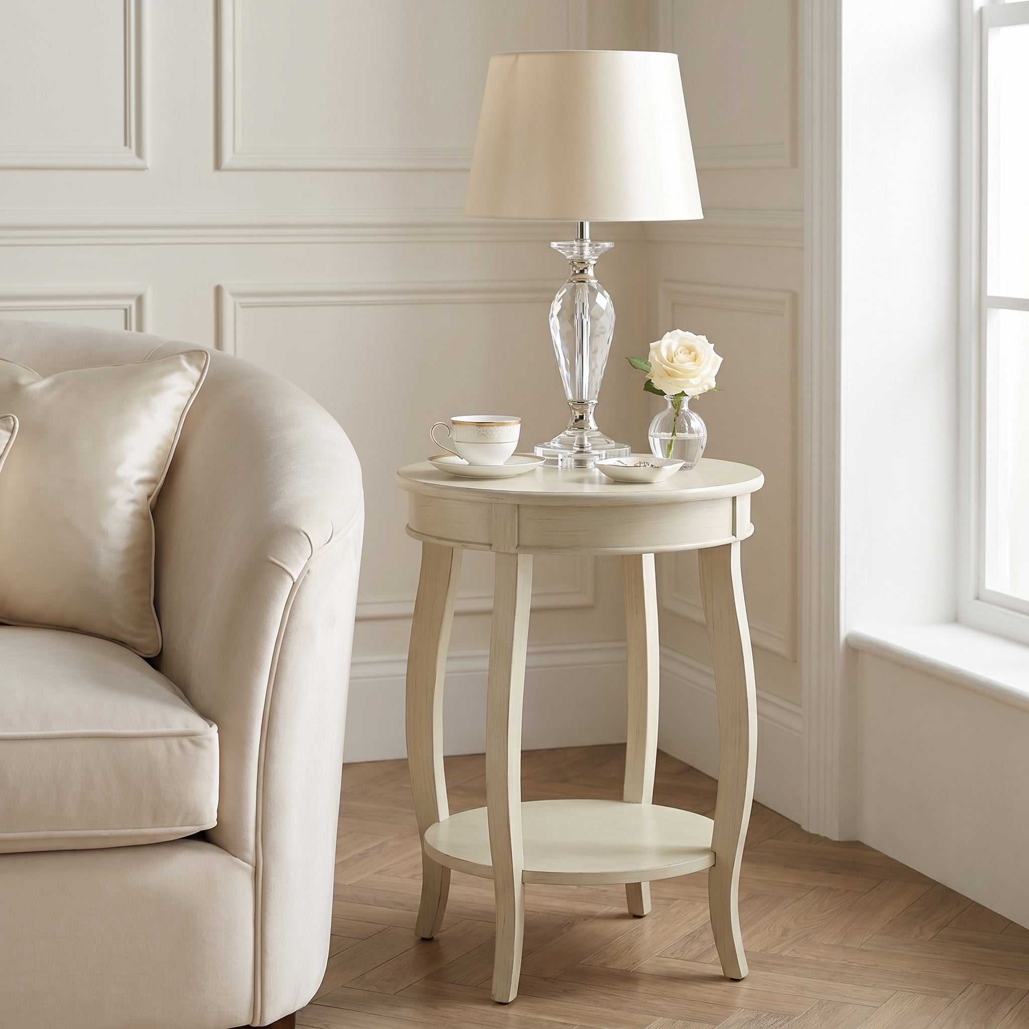 Gila white side table showing a round end table by a sofa in a bright corner