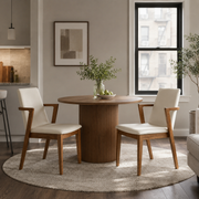 Isar beige upholstered dining chairs with solid rubberwood arm frame around a round dining table