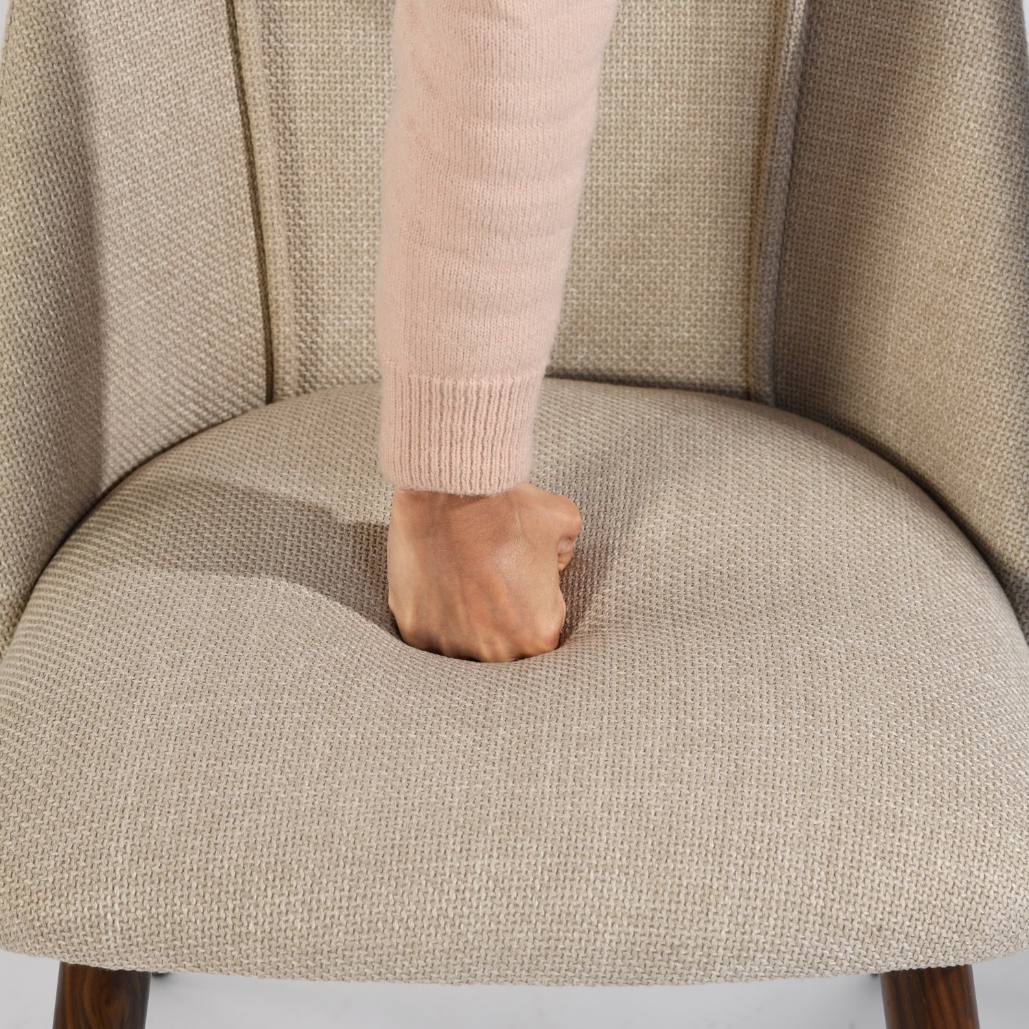 Kali beige upholstered dining chair showing cushioned seat pressed by hand
