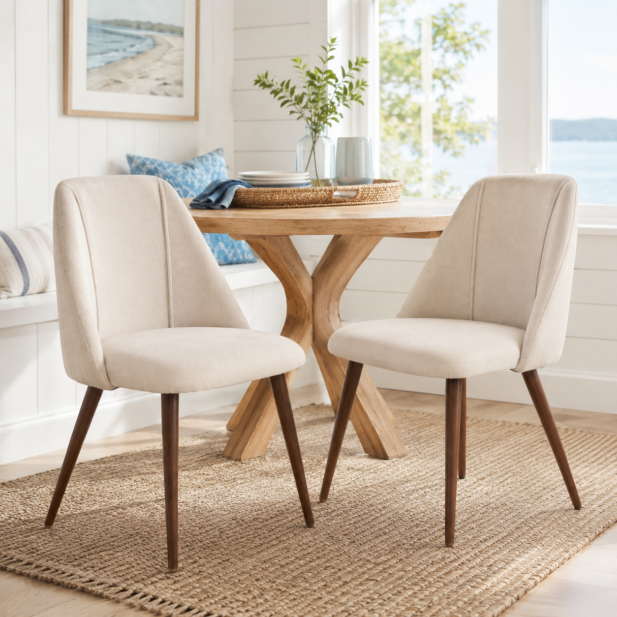 Kali beige upholstered dining chairs with walnut-tone tapered metal legs set of 2 around a round pedestal table in a bright dining room