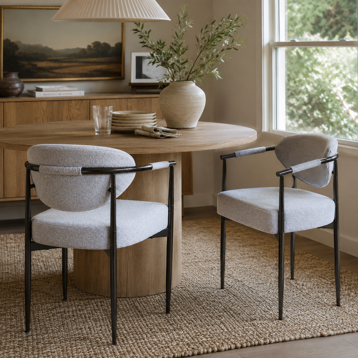 Kariba gray upholstered dining chairs beside a round dining table in a warm contemporary room