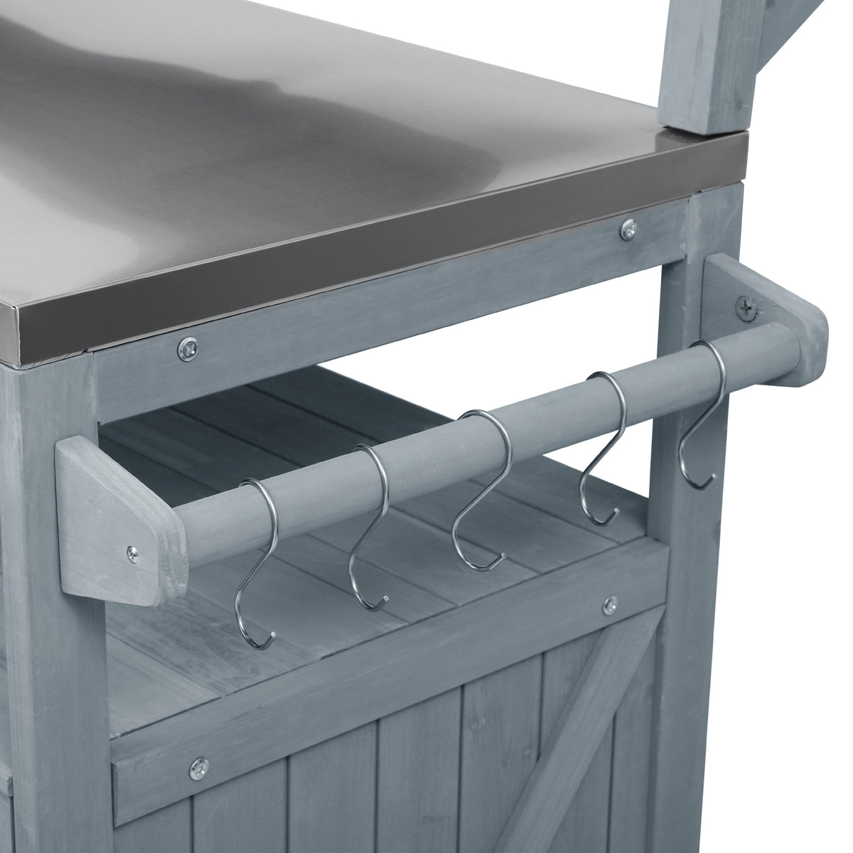 Close-up of the utensil hanging rod with metal hooks on the gray blue Limoges outdoor kitchen island beside the stainless steel countertop for organizing grilling tools and outdoor cooking accessories