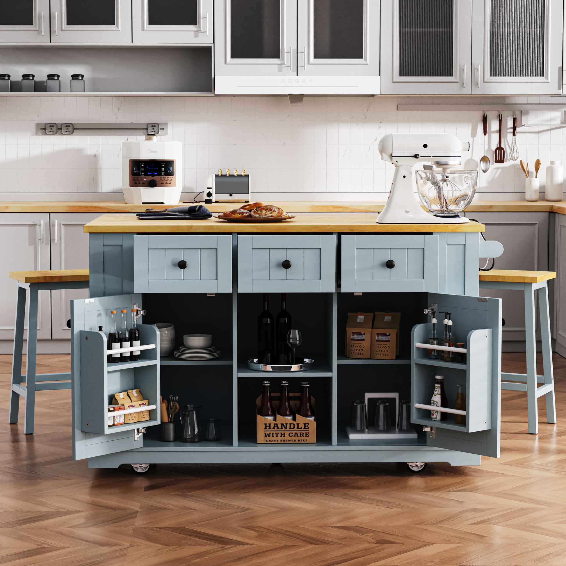 Front view of Maui gray blue rolling kitchen island with open cabinet storage drawers door mounted spice racks matching stools and expandable countertop in kitchen scene