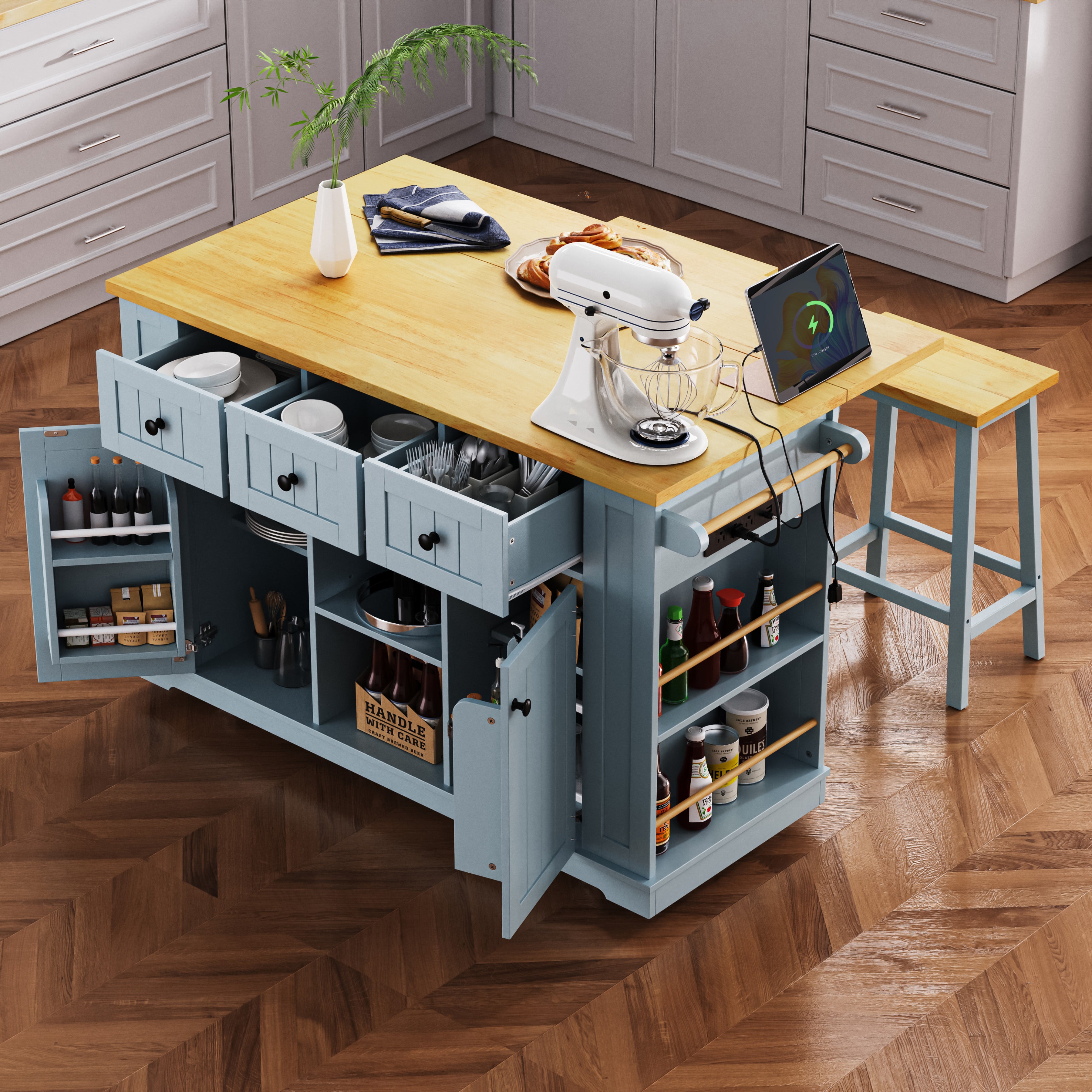 Maui gray blue rolling kitchen island with expandable drop leaf countertop open side shelves power outlet drawers cabinet storage and matching stool in modern kitchen scene