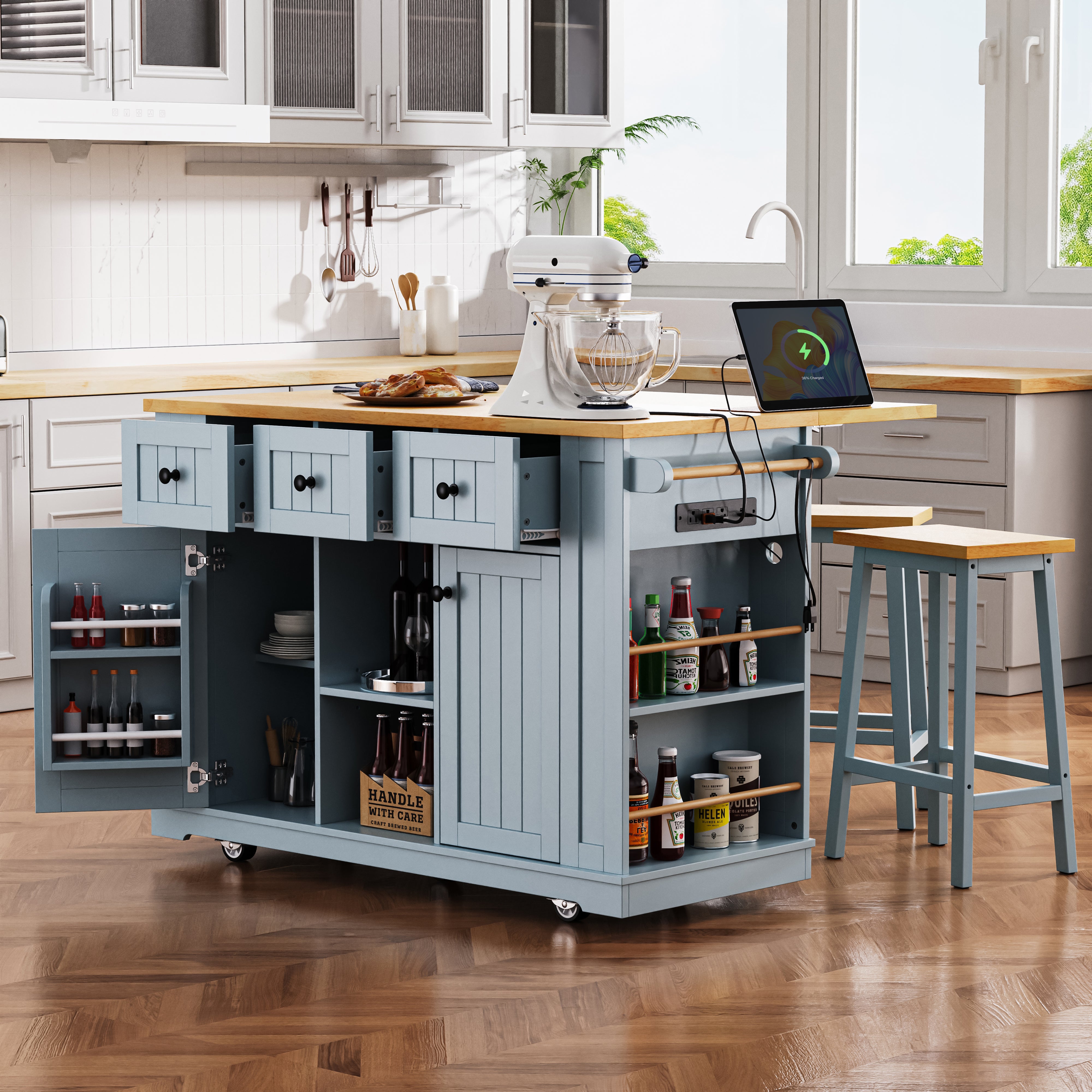 Maui gray blue rolling kitchen island with built in power outlet open side spice shelves expandable drop leaf countertop cabinet storage and matching stools in kitchen scene