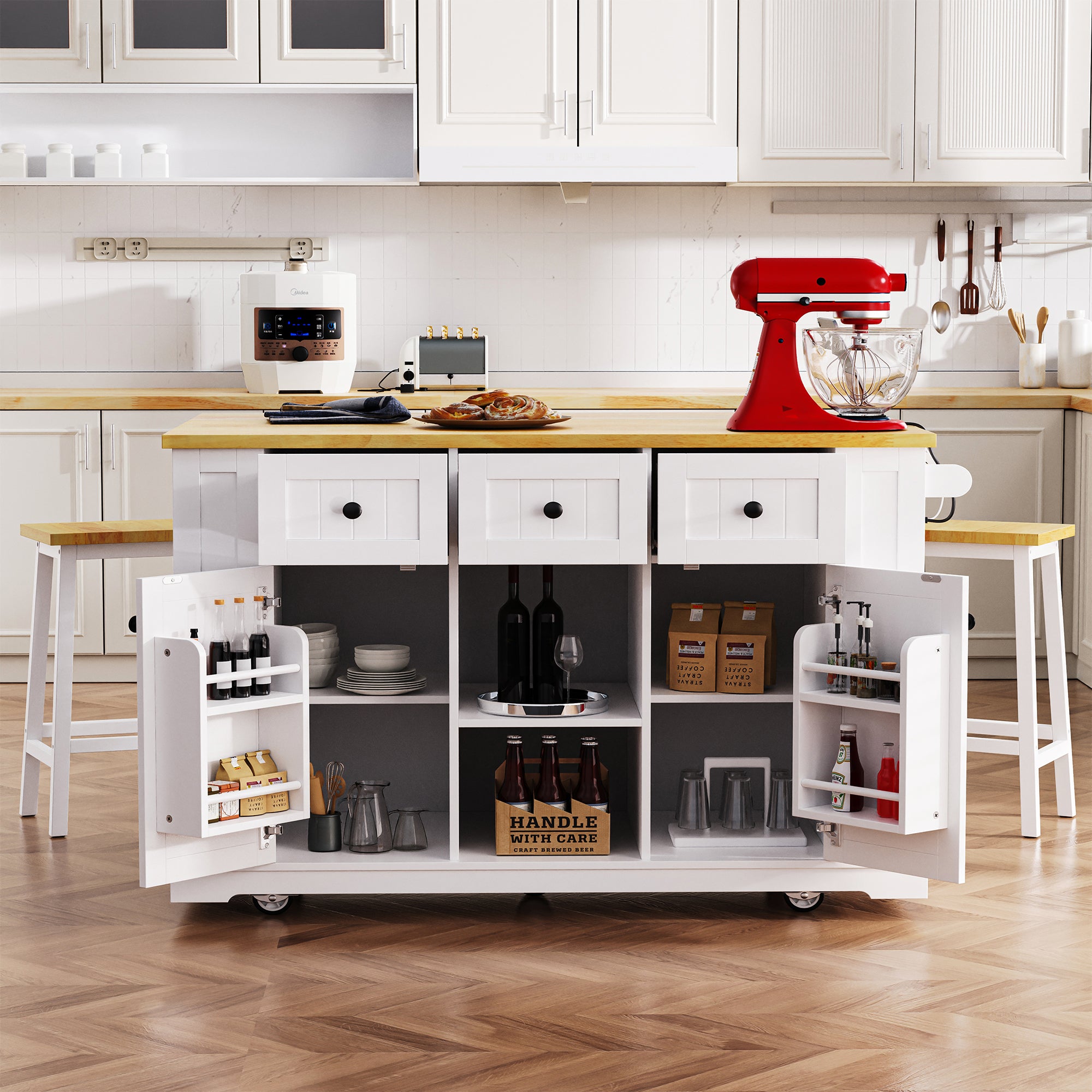 Front view of Maui white rolling kitchen island with open cabinet storage drawers door mounted spice racks matching stools and expandable countertop in kitchen scene