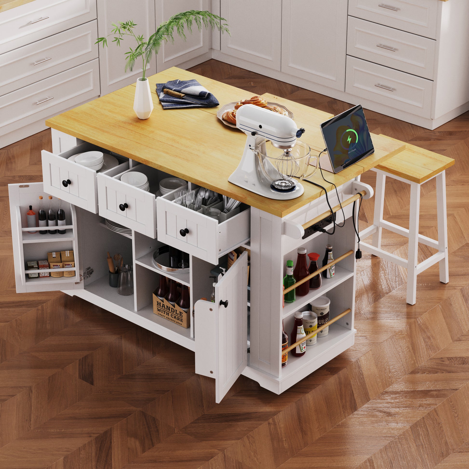 Maui white rolling kitchen island with expandable drop leaf countertop built in power outlet open side spice shelves drawers cabinet storage and matching stool in kitchen scene