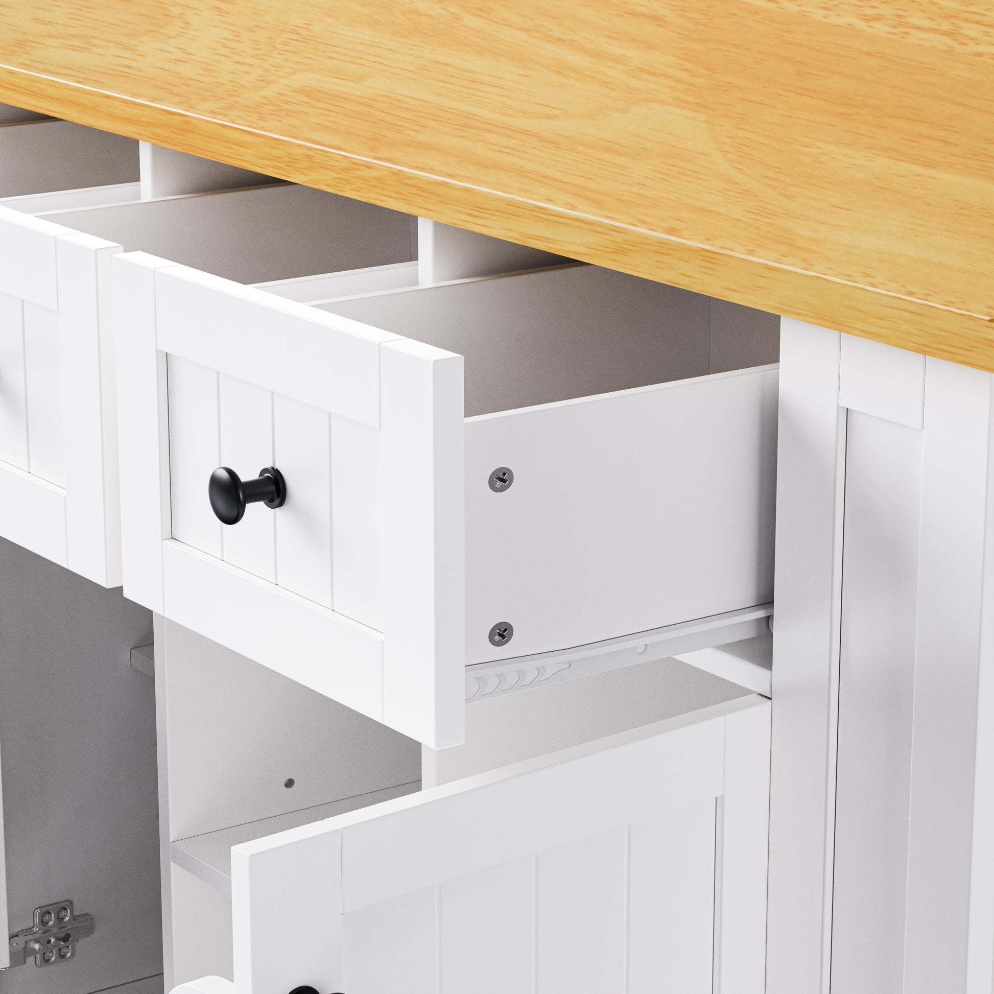 Close-up detail of Maui white rolling kitchen island featuring spacious storage drawer with smooth slide rails and farmhouse panel front design