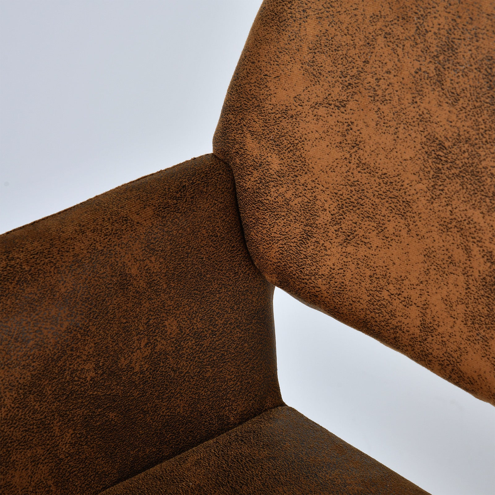 Mayfair suede brown dining chair showing curved armrest and side upholstery detail