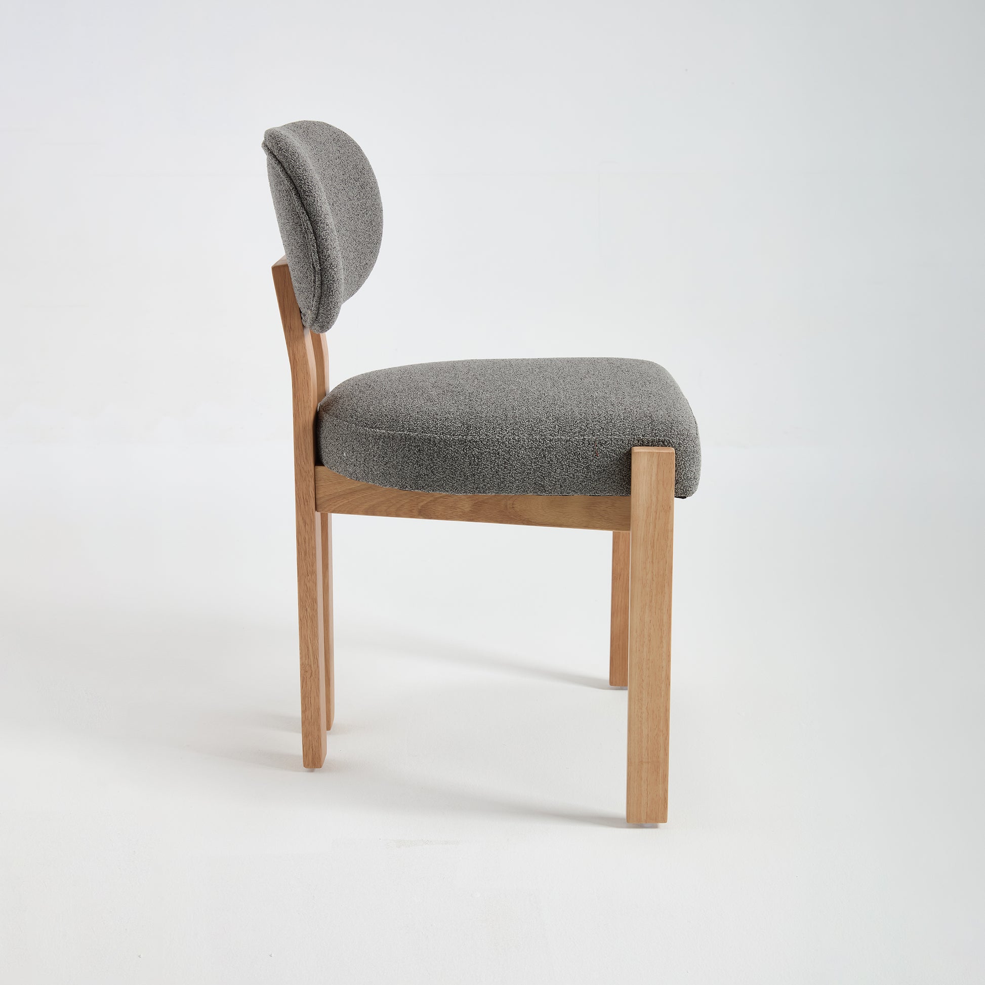 Michigan gray upholstered dining chair side view with rubberwood legs on white background