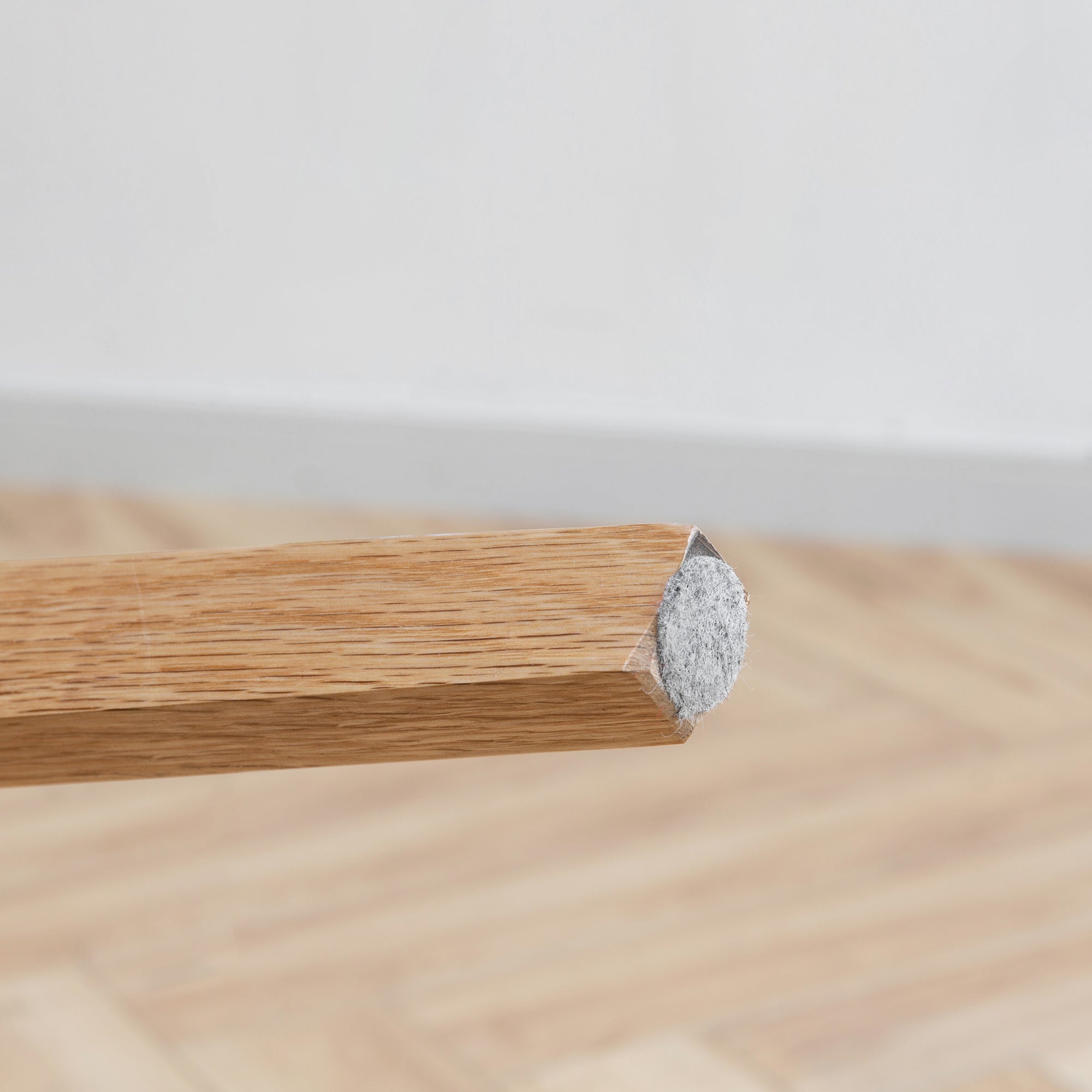 Mogan oak dining chair close-up of the tapered solid wood leg with floor protector