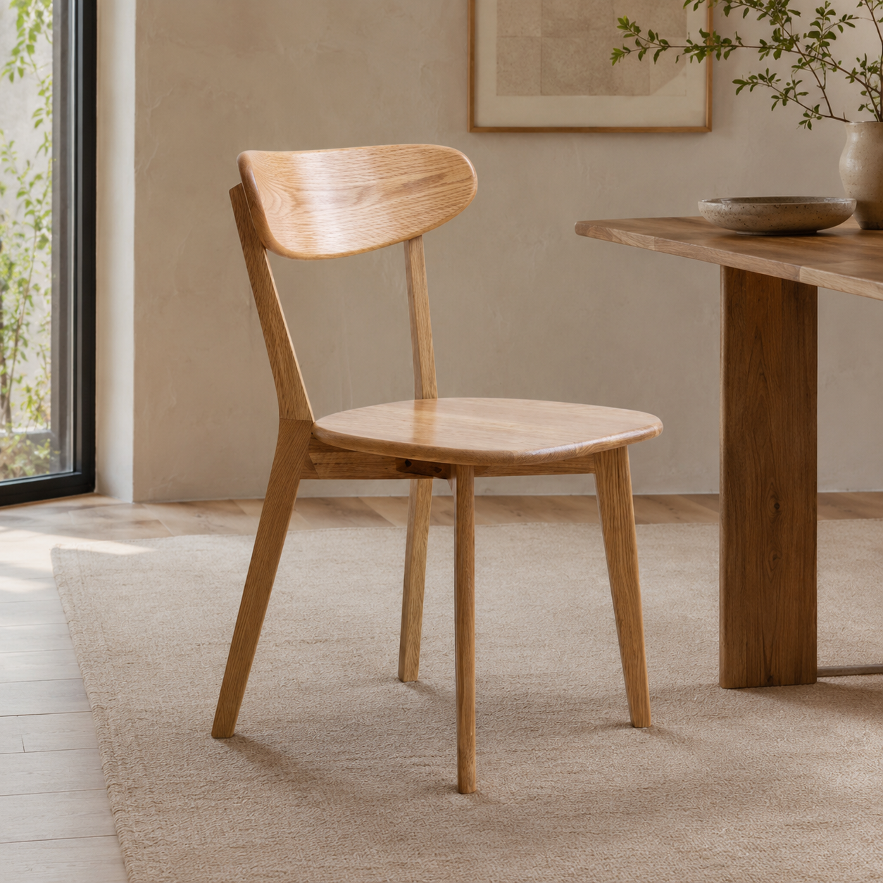 Mogan oak solid wood dining chair beside a wood dining table in a bright minimalist dining room