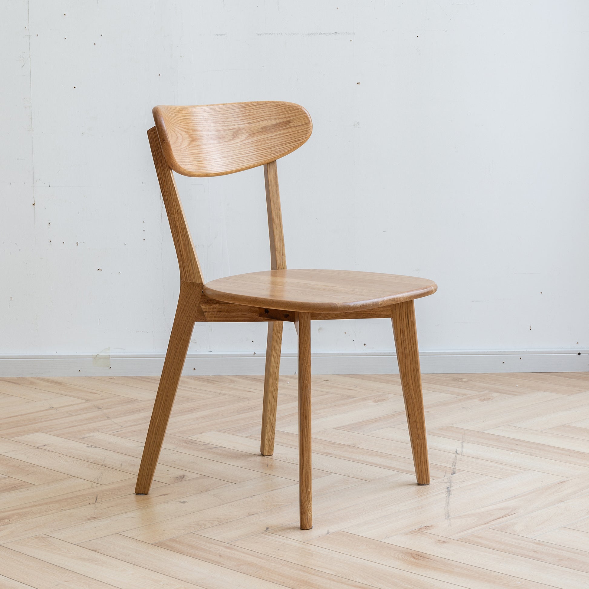 Mogan oak dining chair front angled view with curved wooden backrest on white background