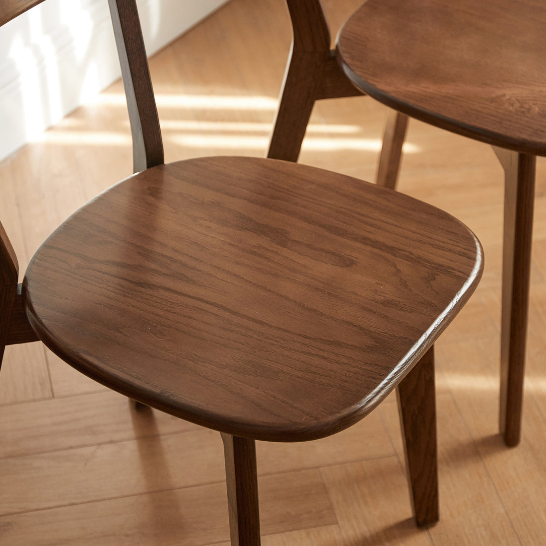Mogan walnut dining chair close-up of the contoured solid wood seat and natural wood grain