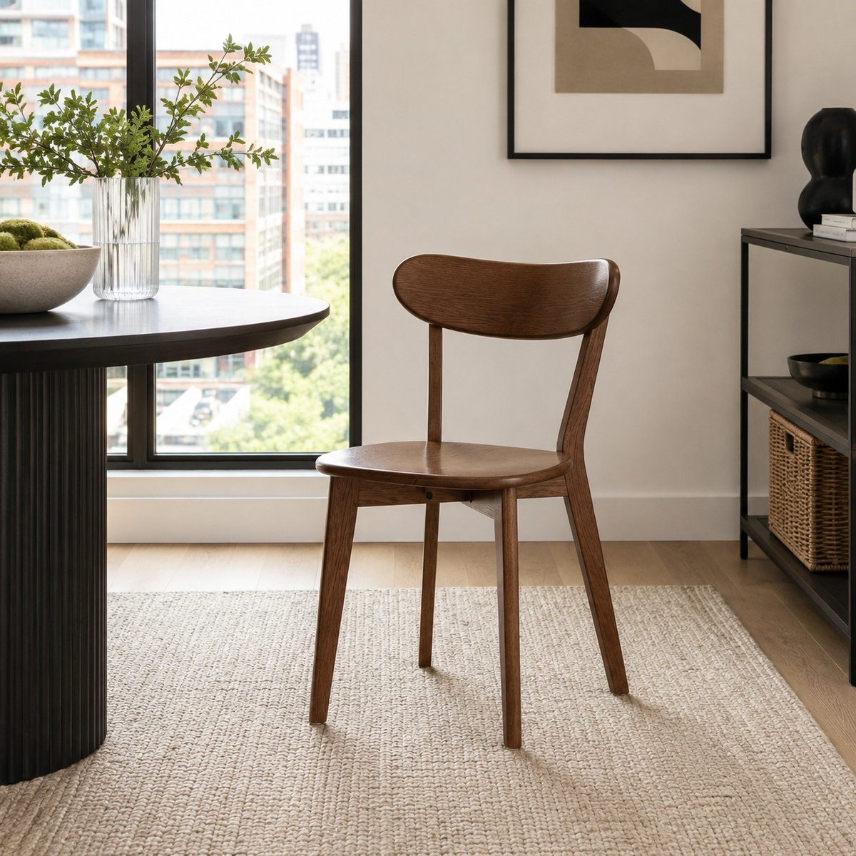 Mogan walnut dining chair beside a round wood table in a sunlit dining room