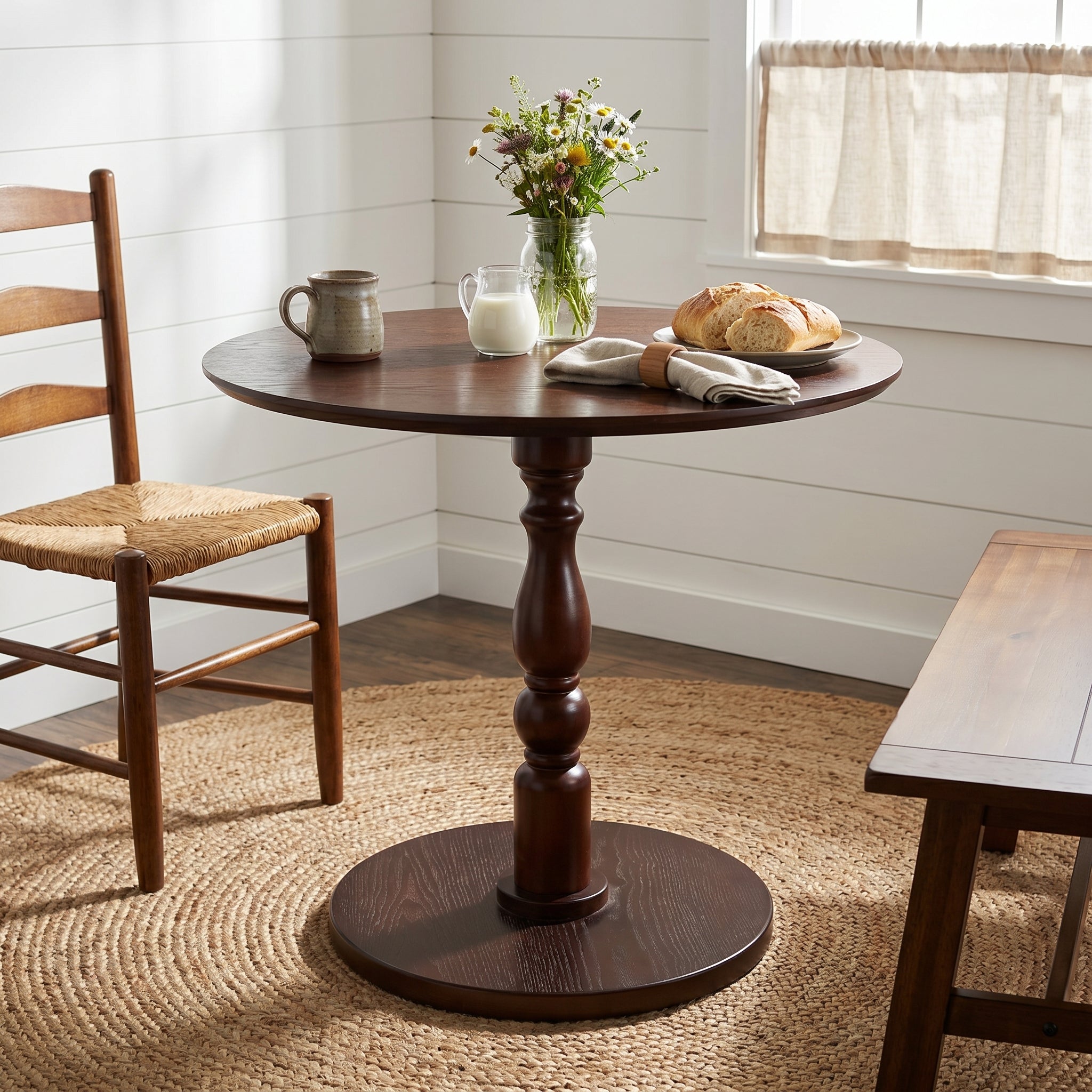Monaco walnut side table showing a pedestal table with chairs in a sunlit room