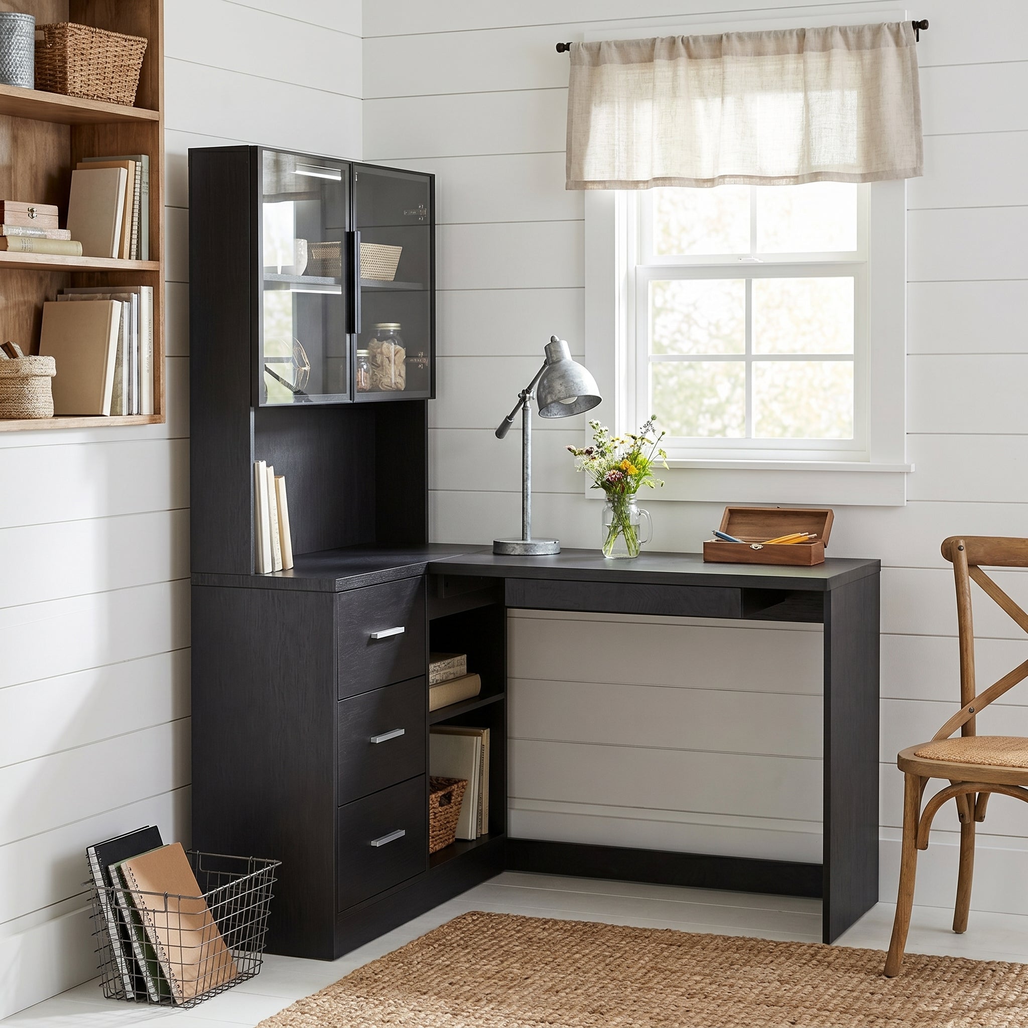 Nord black computer desk showing an L-shaped desk with glass cabinets in a bright home office