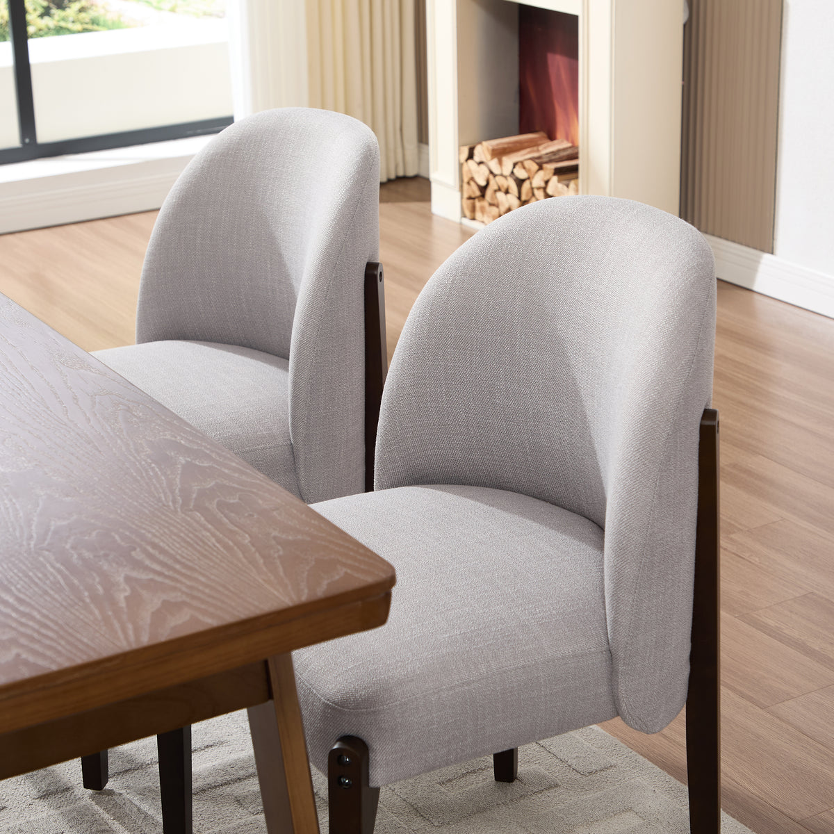 Orta gray dining chair close-up of the upholstered barrel back and dark wood frame