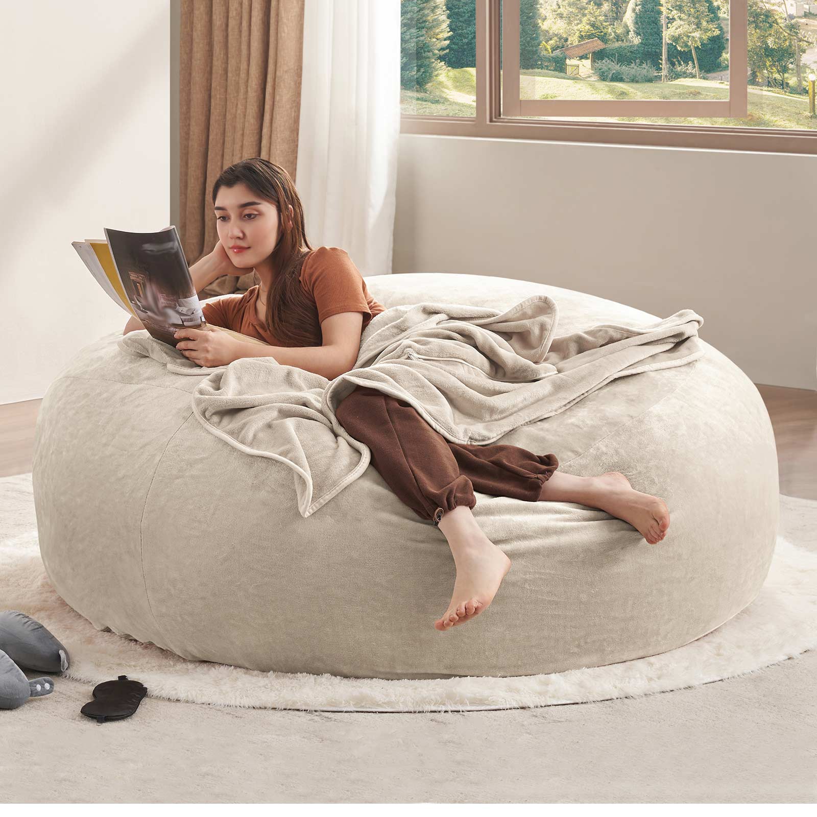 Pebble beige bean bag chair showing a woman reclining with a book in a bright living room